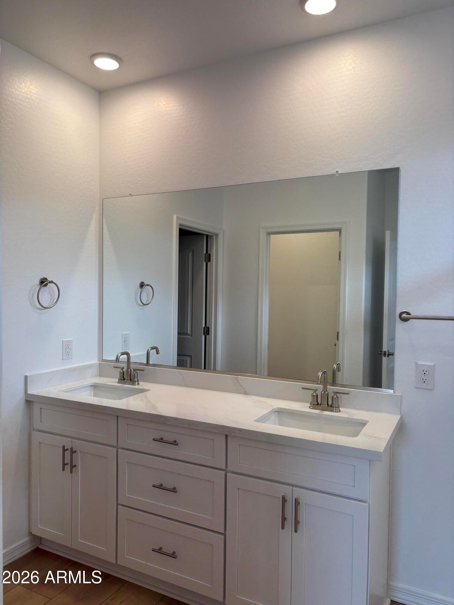 Dual-sink bathroom vanity with white cabinets, quartz countertop, and large mirror in Davidson Homes The Evergreen B, Cottonwood AZ