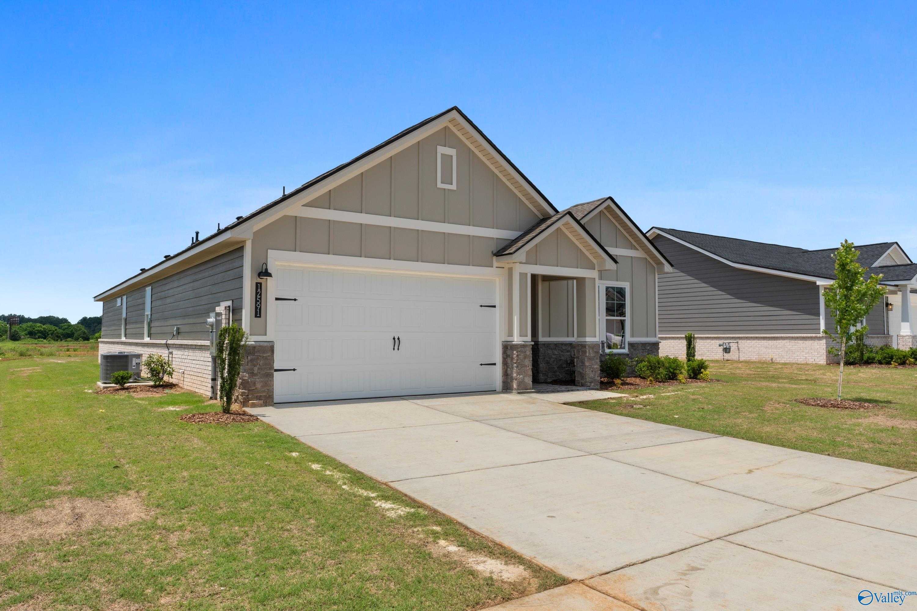 Modern 1-story gray home with 2-car garage, stone accents, and landscaped yard in Anderson Farm, Athens, Alabama
