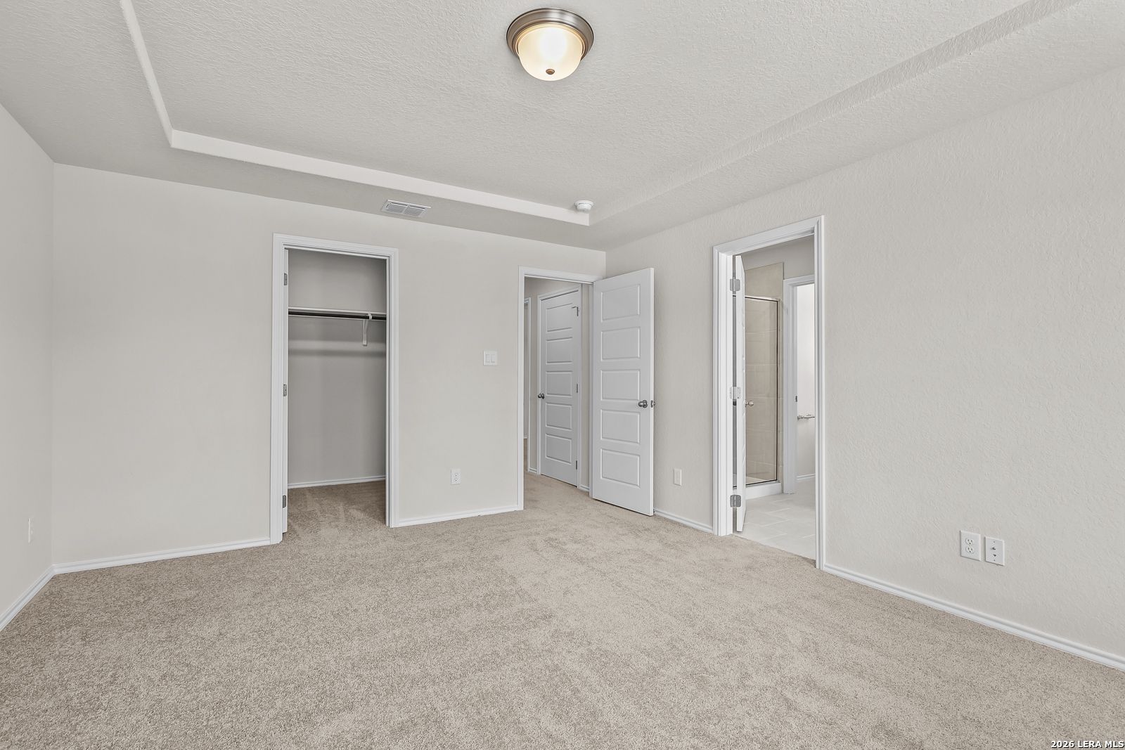 Spacious secondary bedroom with walk-in closet and en-suite bathroom access in The Gillian B floor plan, San Antonio, Texas.