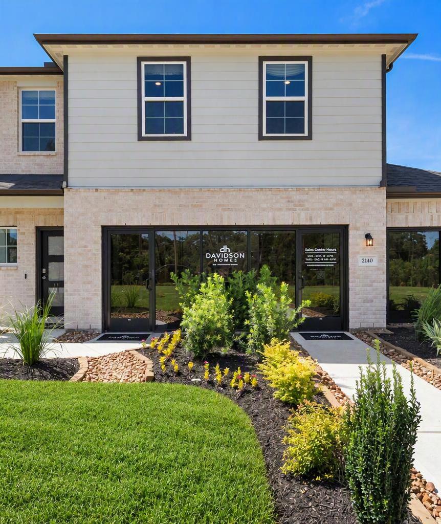 Spacious living room in Caney Creek Place Conroe TX with beige sectional sofa, emerald green velvet chairs, hardwood floors, ceiling fan, and modern art