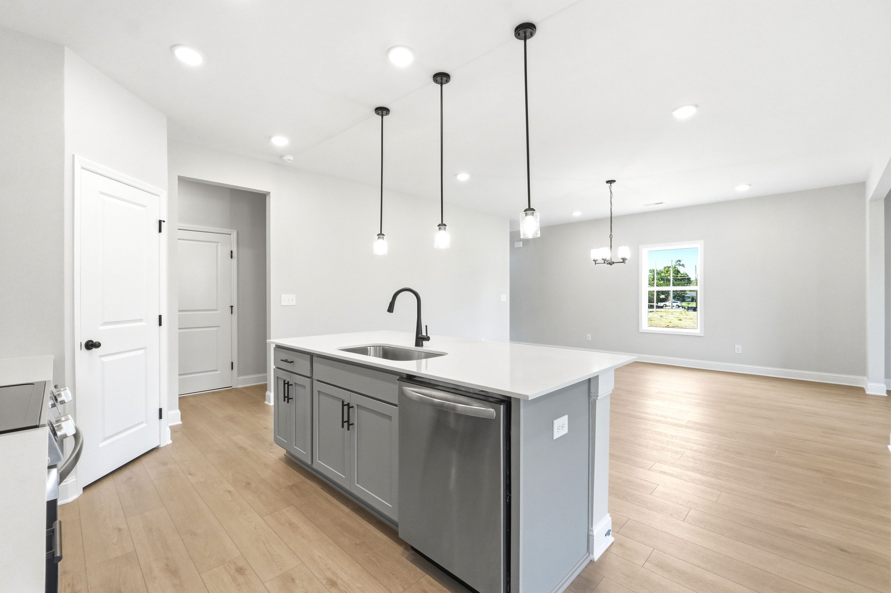 Modern kitchen island with quartz countertops and pendant lighting in The Russell A floor plan by Davidson Homes.