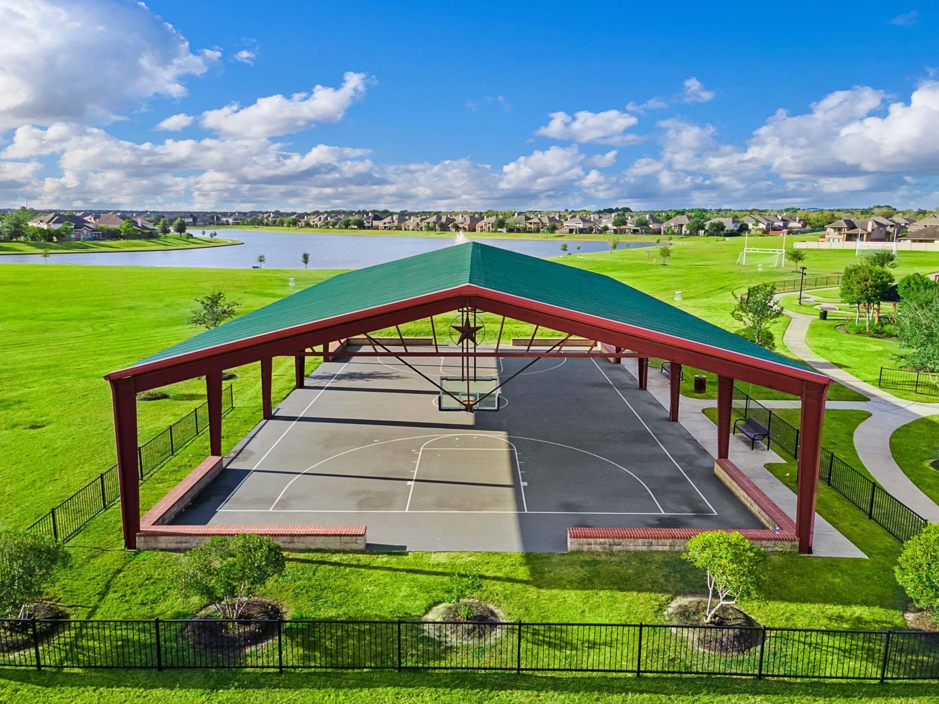 Covered basketball court at Sierra Vista community park with lake views in Rosharon, Texas.