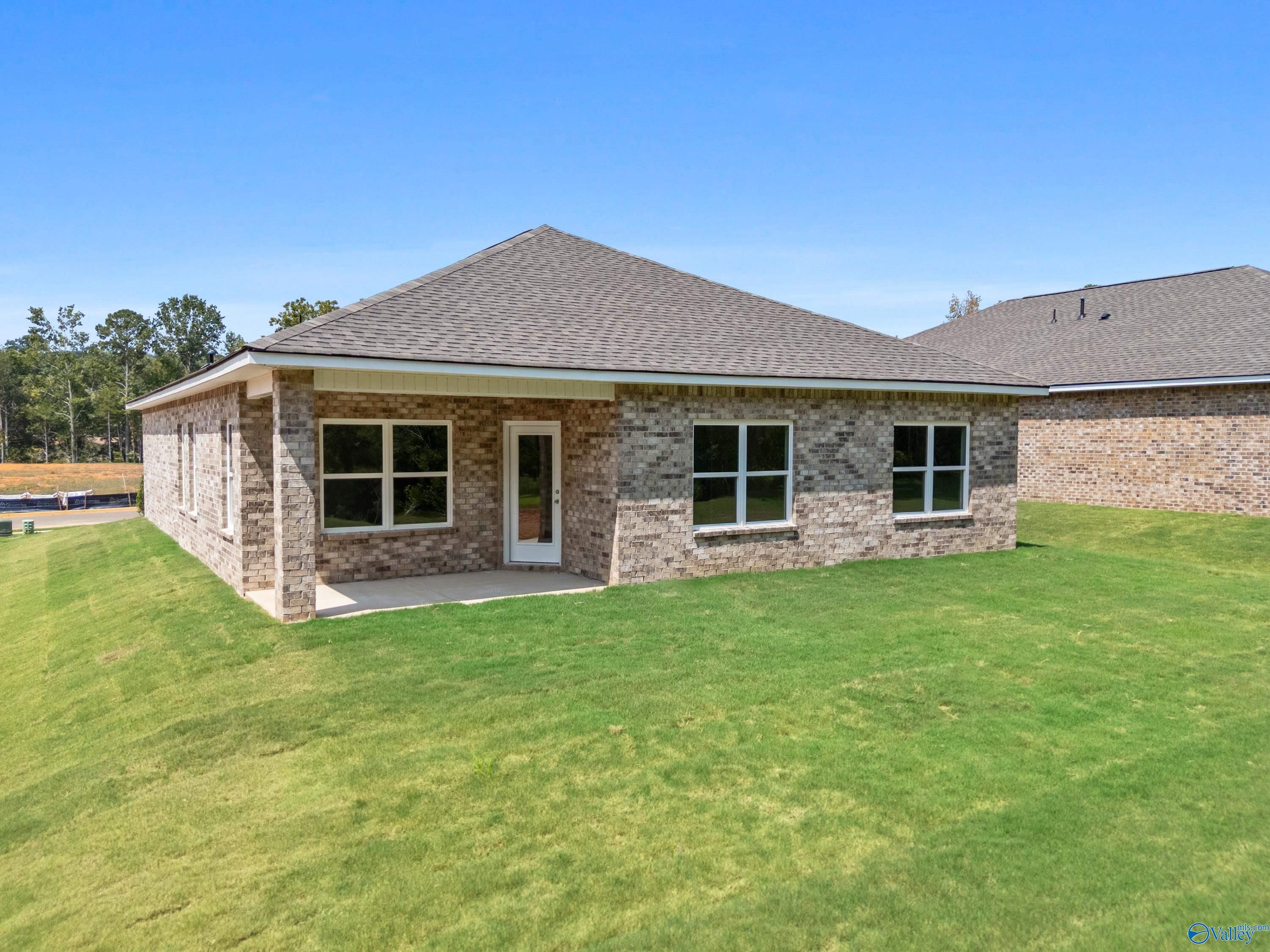 Single-story brick home with covered entry, double windows, and shingled roof on green lawn in Spragins Cove, Huntsville, Alabama - The Franklin by Davidson Homes