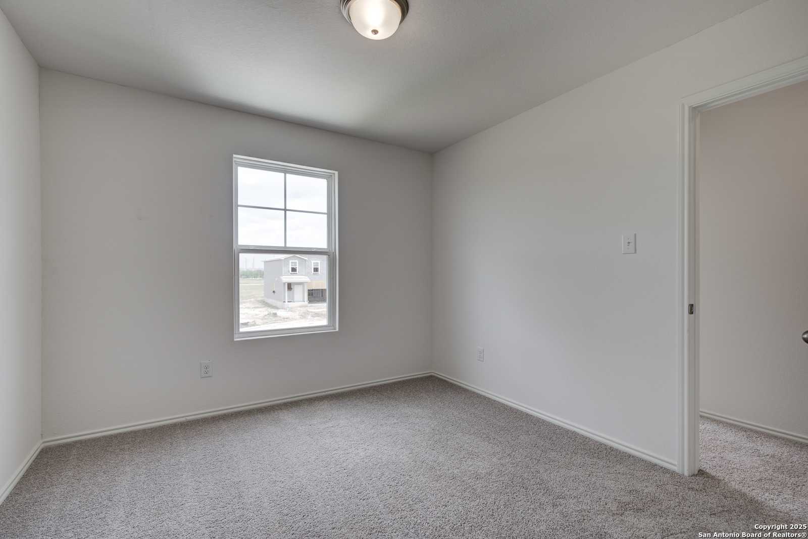 Bright secondary bedroom with neutral walls, carpet flooring, and large window in Davidson Homes Trinity A, Applewhite Meadows, San Antonio