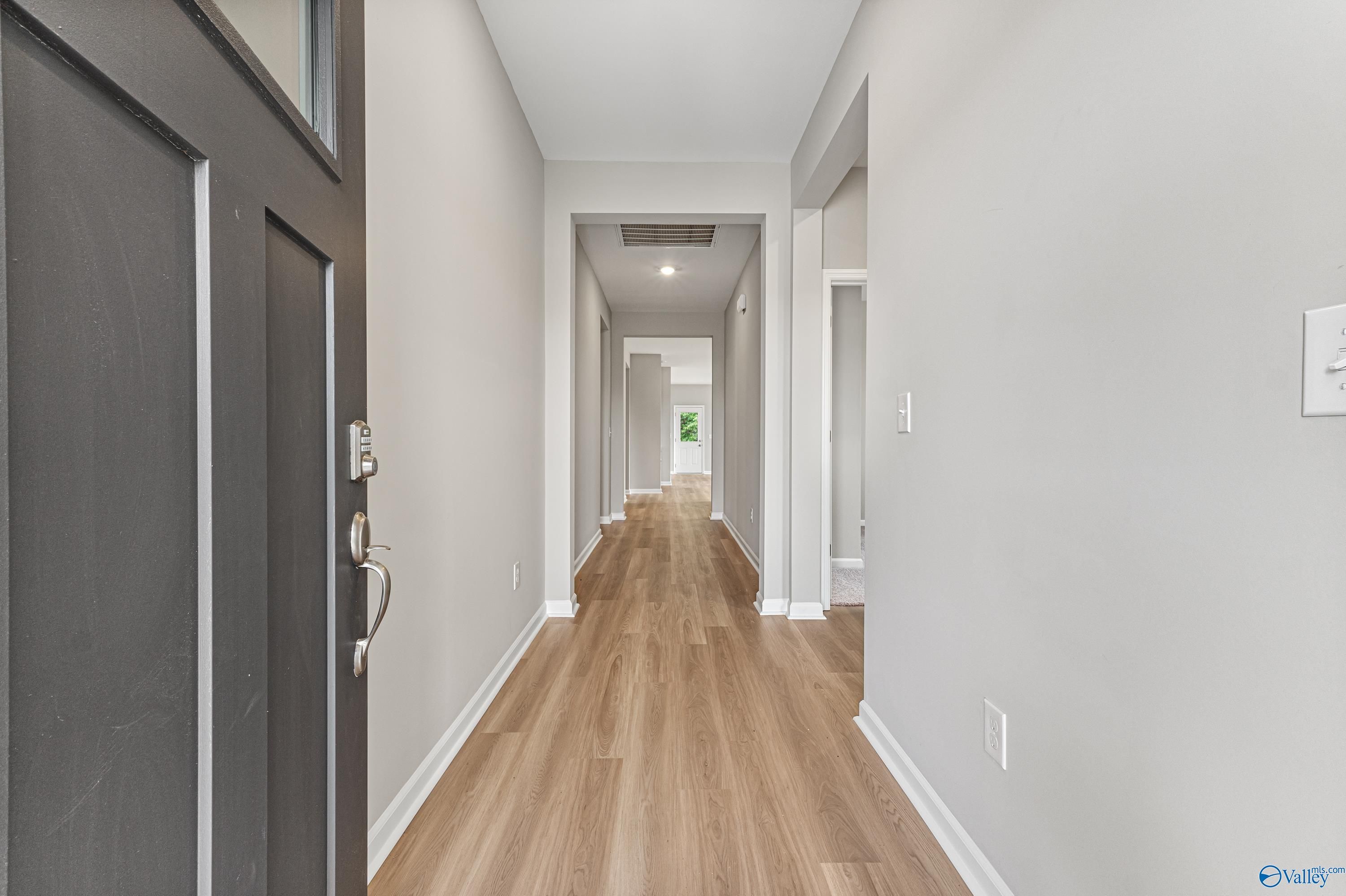 Bright entry hallway with hardwood floors and bedroom doors in Davidson Homes The Aurora, Fayetteville, TN