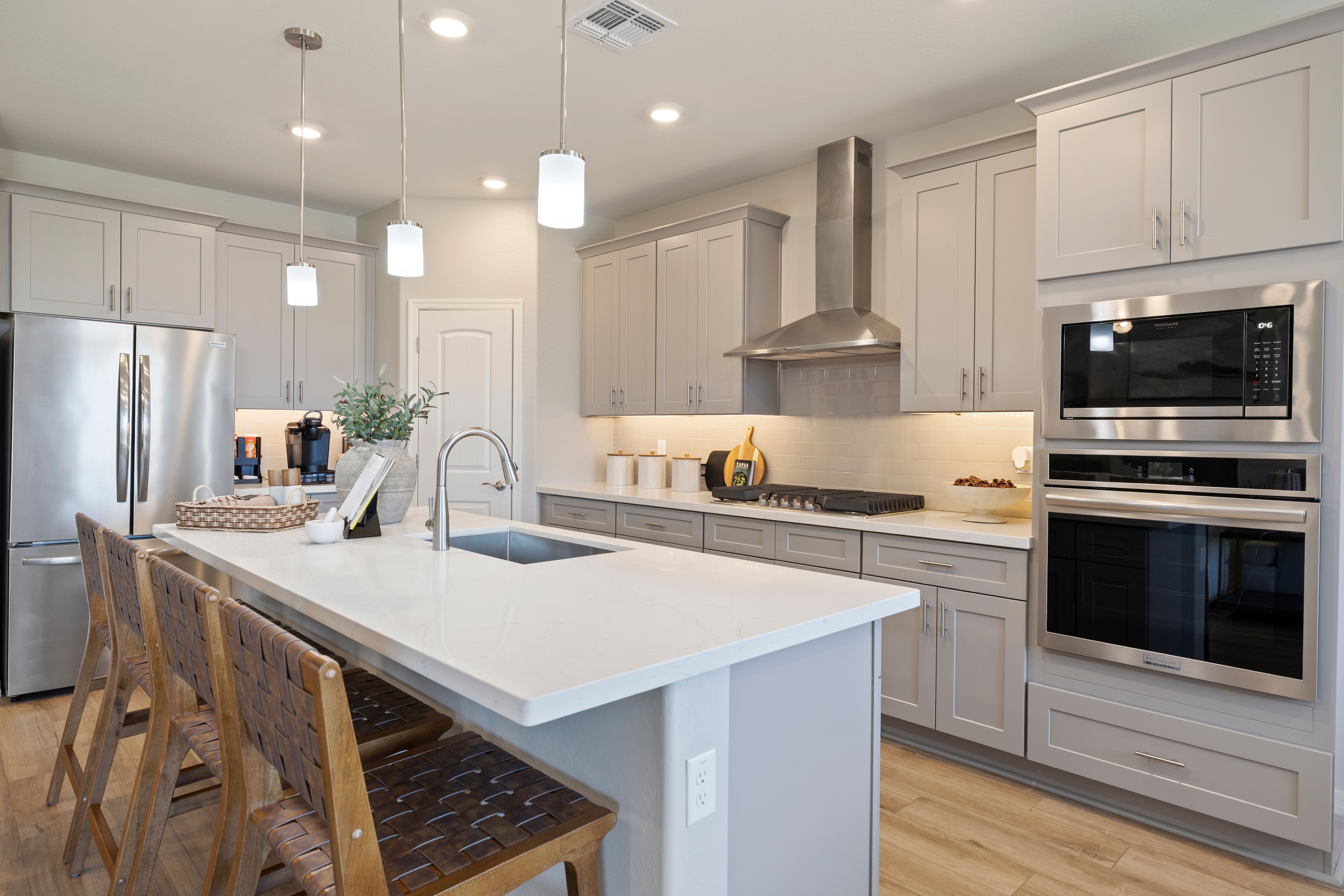 Spacious modern kitchen at North Ridge Pronghorn Ranch in Prescott Valley AZ with gray cabinets, white quartz island, and stainless steel appliances