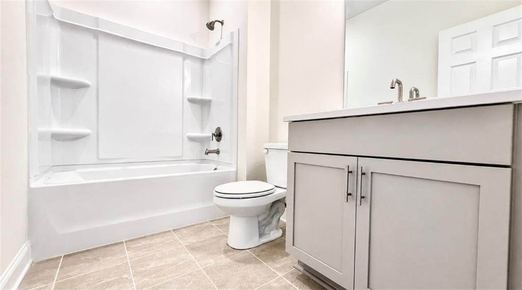 Modern bathroom with white tub-shower combo and vanity in The Hickory C floor plan at Wehunt Meadows, Hoschton, Georgia.