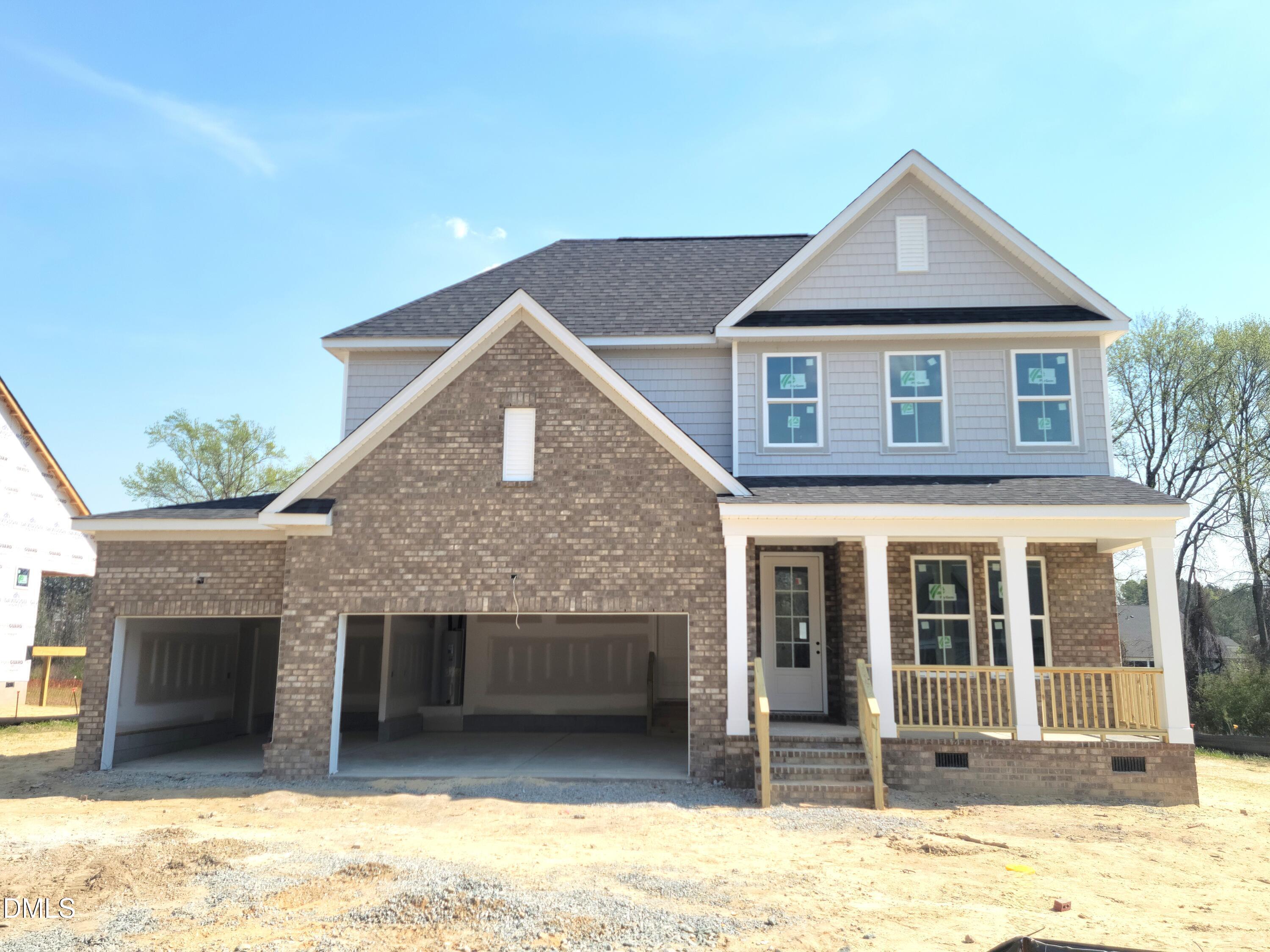 Two-story brick home with 3-car garage, covered front porch, and gabled roof in Tobacco Road, Angier, NC - Davidson Homes Ashport G