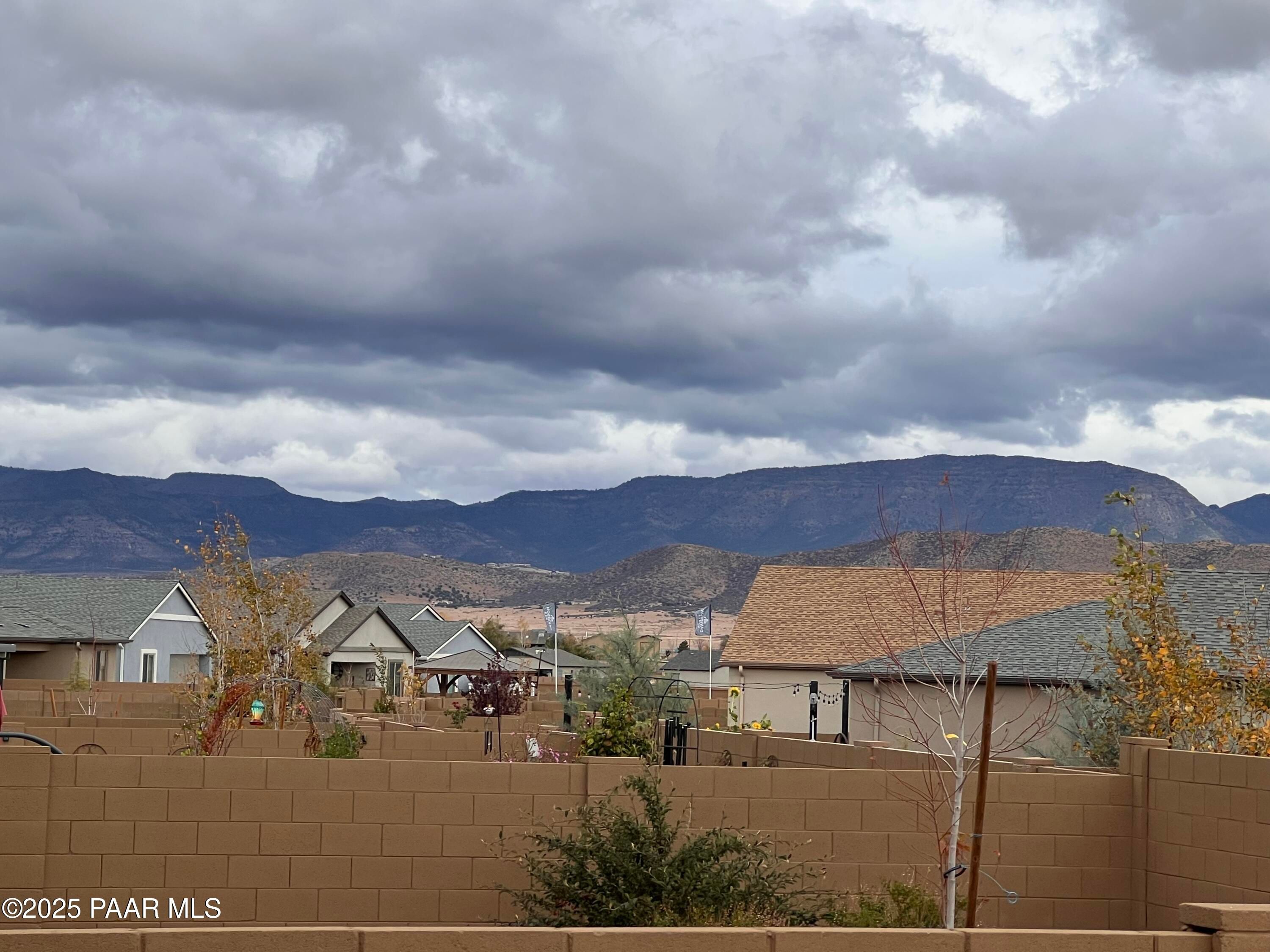 Scenic neighborhood of single-story homes with mountain backdrop and cloudy skies in North Ridge at Pronghorn Ranch, Prescott Valley, Arizona