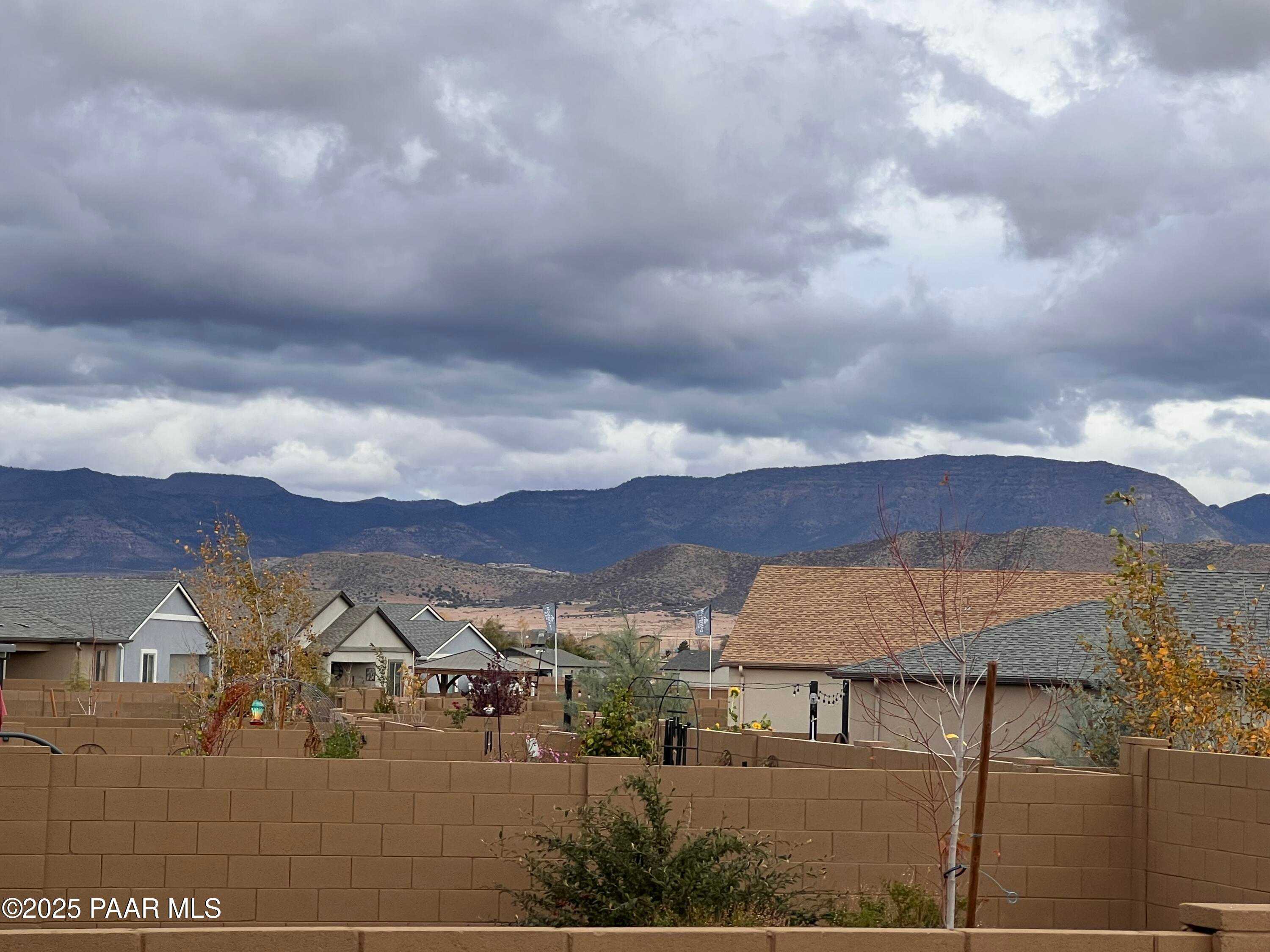 Scenic neighborhood of single-story homes with mountain backdrop and cloudy skies in North Ridge at Pronghorn Ranch, Prescott Valley, Arizona