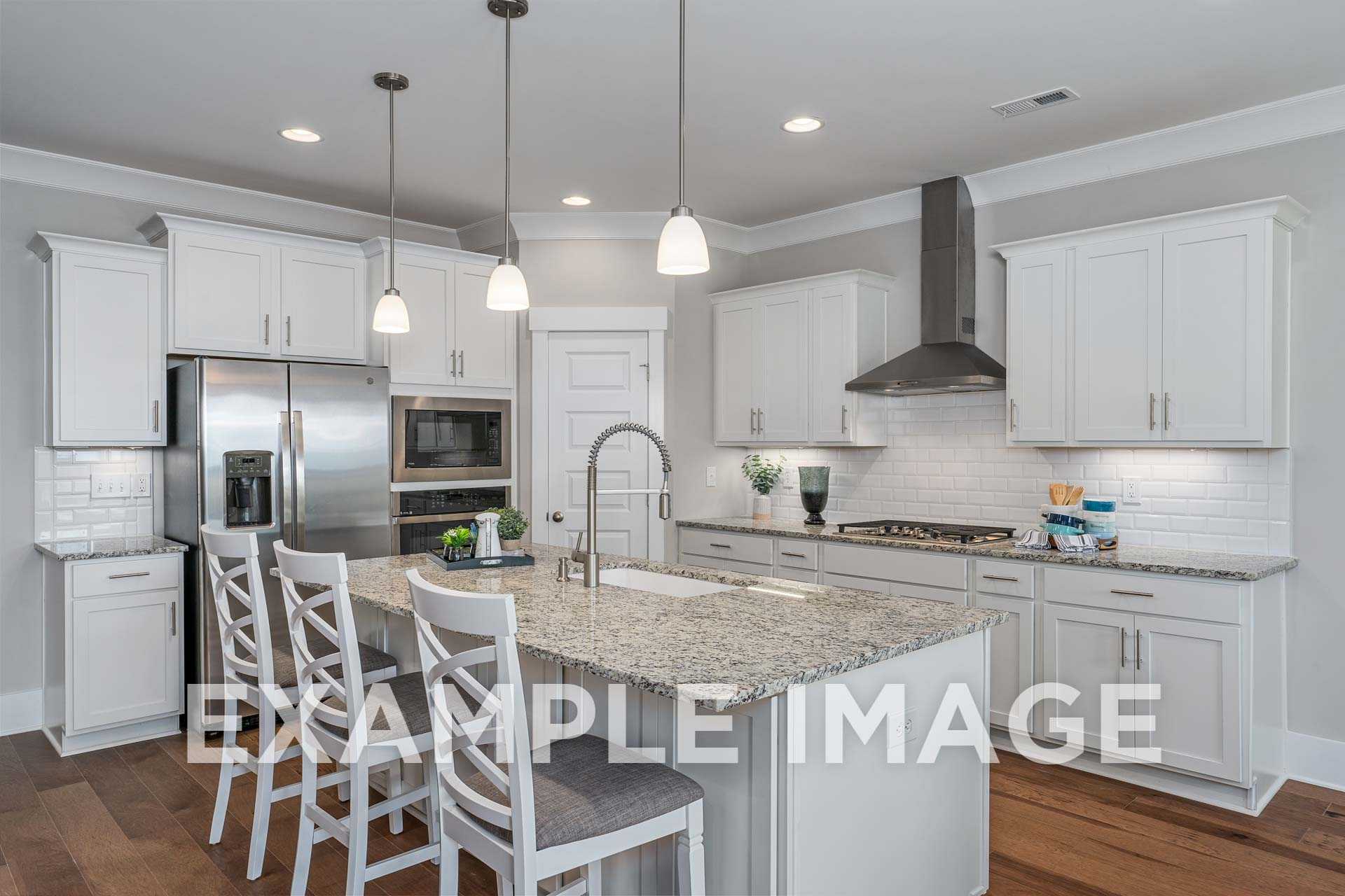 Spacious kitchen in The Harrison by Davidson Homes featuring white shaker cabinets, granite island, stainless steel appliances