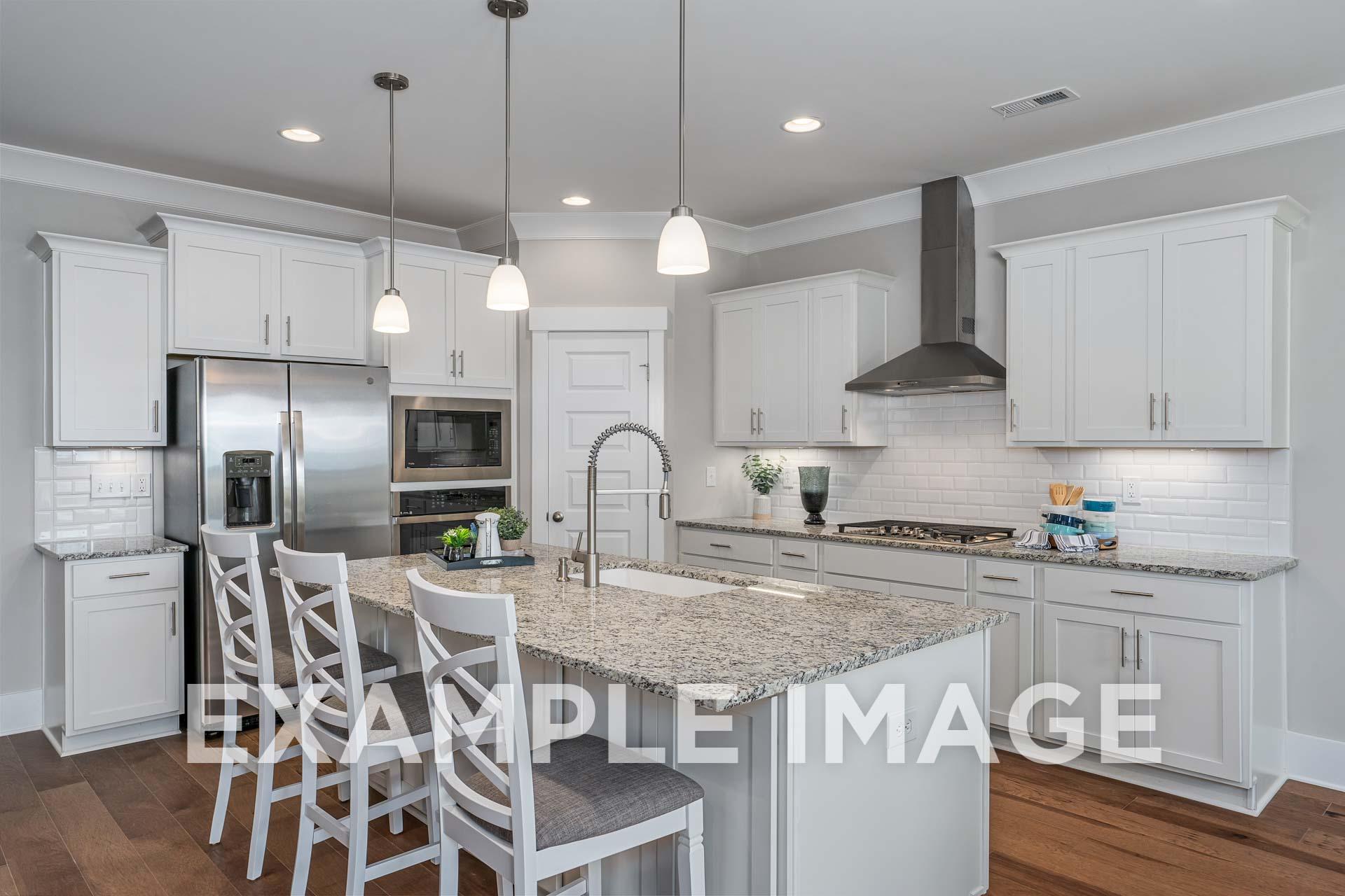 Spacious kitchen in The Harrison home featuring white shaker cabinets, granite island, stainless appliances