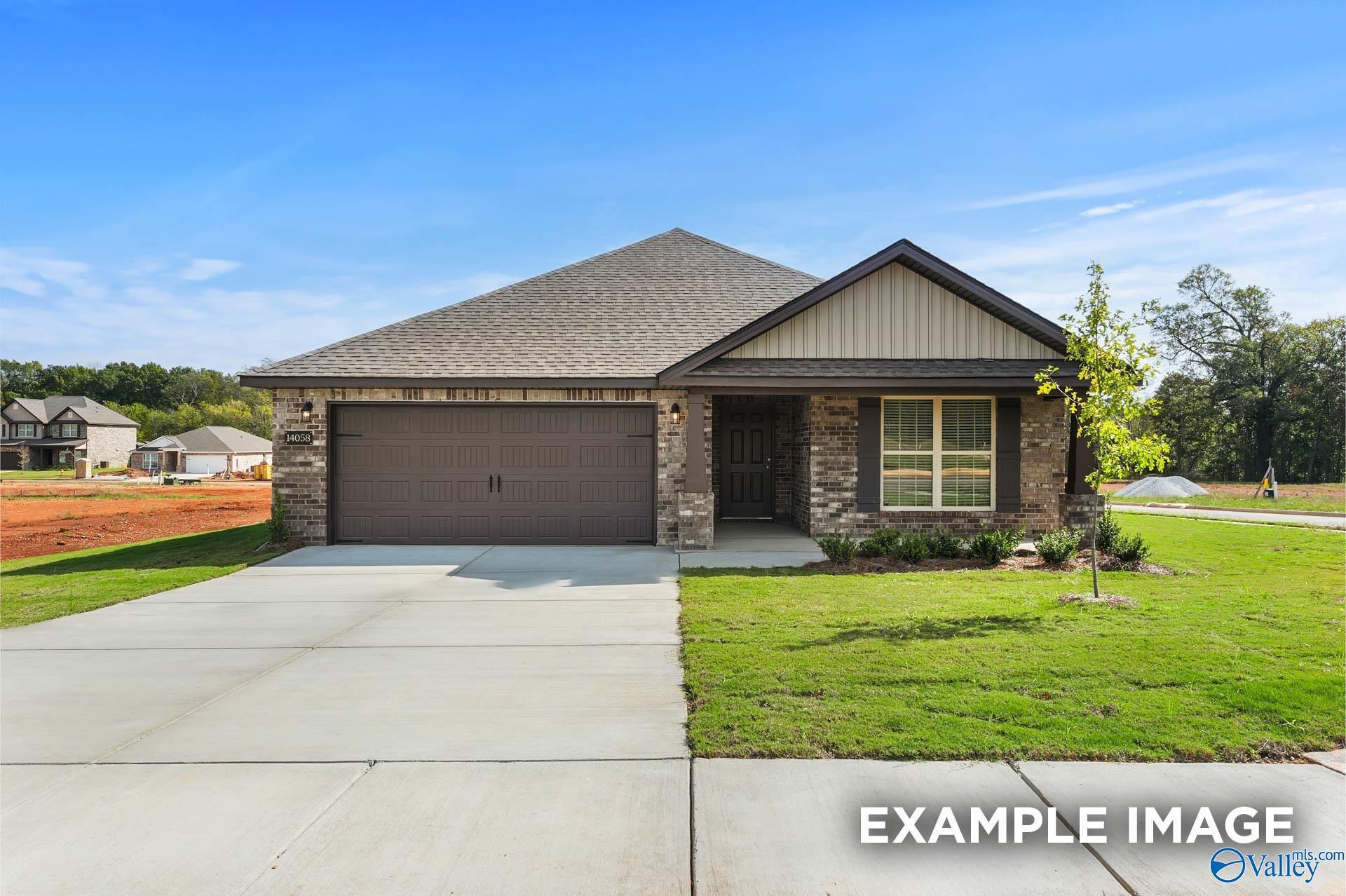 Modern 4-bedroom single-story home with brick facade, 2-car garage, driveway, and lush lawn in Wood Trail, Toney, Alabama Everett B