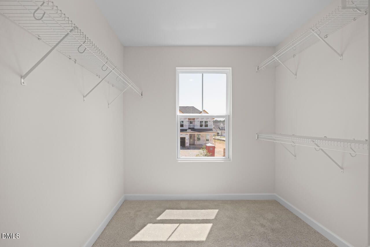 Walk-in closet with wire shelving and natural light in Davidson Homes The Willow B at Woodland Crossing, Zebulon, NC