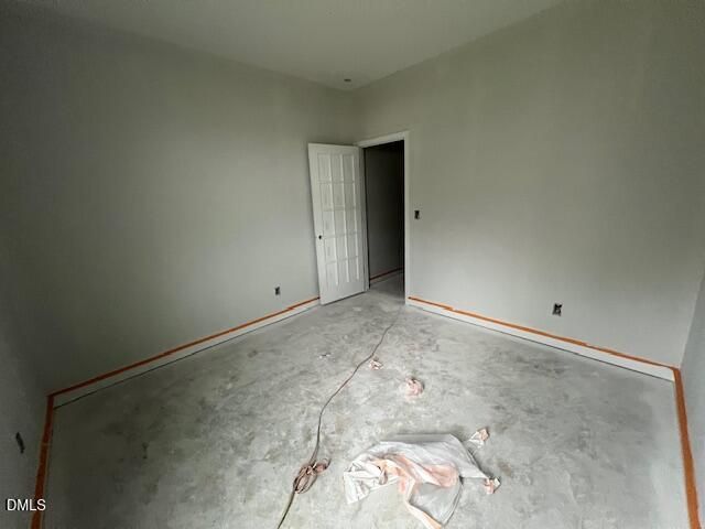 Empty bedroom with fresh painted walls and concrete floor in new construction Davidson Homes The Daphne C plan, Wellers Knoll, Lillington NC