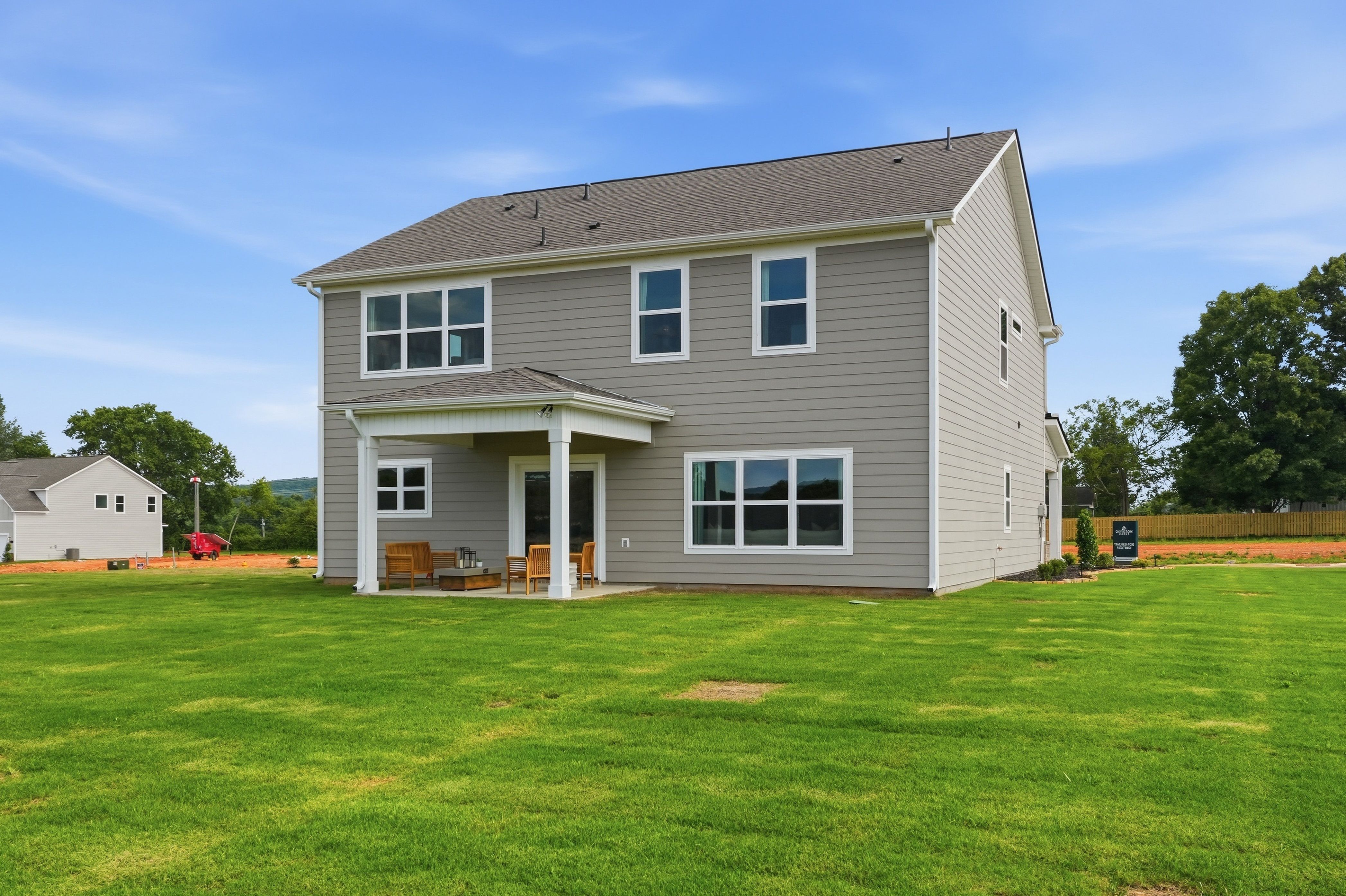 Two-story Davidson Homes exterior at Berry Cove in New Market, Alabama with a covered back patio and spacious backyard.