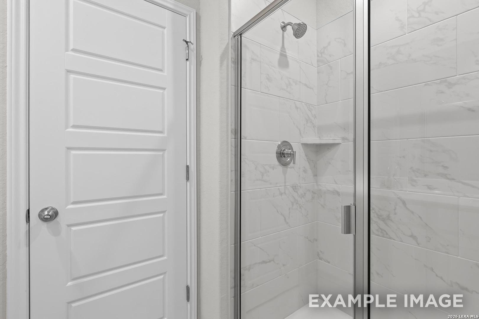 Modern glass shower with white subway tiles and chrome fixtures in master bath of The Colorado D, Davidson Homes, San Antonio
