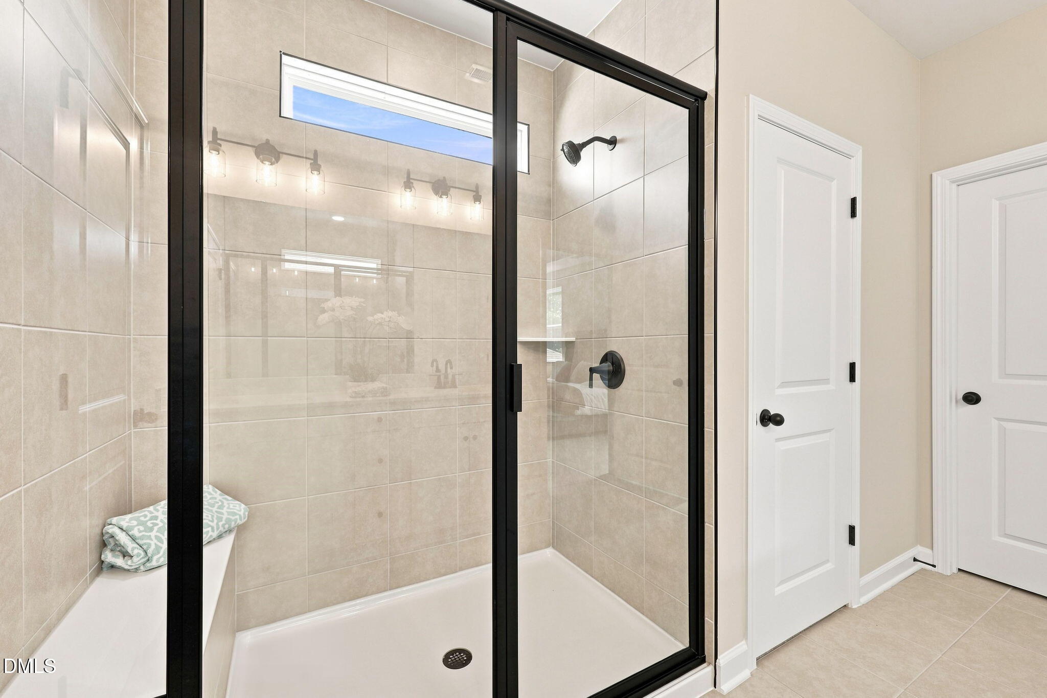 Modern walk-in tile shower with black frame in The Harris C floor plan at Forestville Yard, Knightdale, North Carolina.
