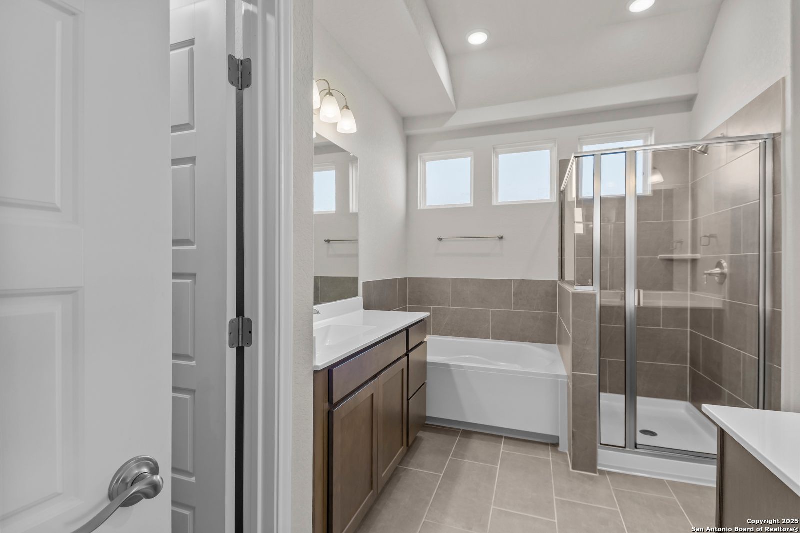 Modern master bathroom with dual vanity, soaking tub, and frameless glass shower in Davidson Homes The Collin B, Seguin, TX