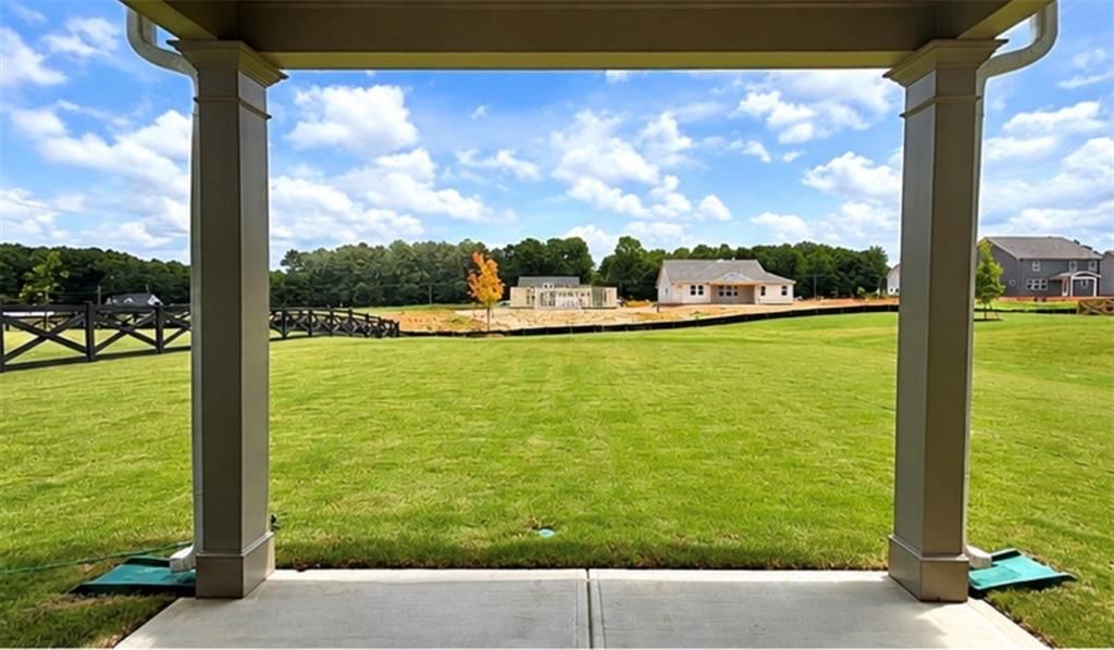 Covered patio view of spacious grassy backyard in Wehunt Meadows, Hoschton, Georgia by Davidson Homes.