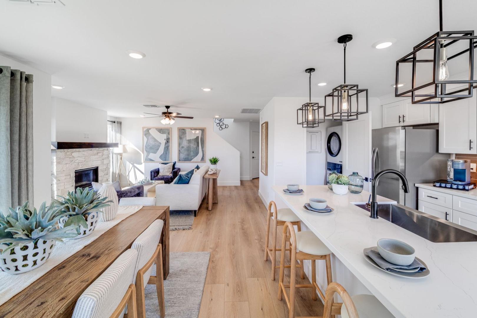 Open-concept living and kitchen in The Wilmington by Davidson Homes, with fireplace, island, and hardwood floors