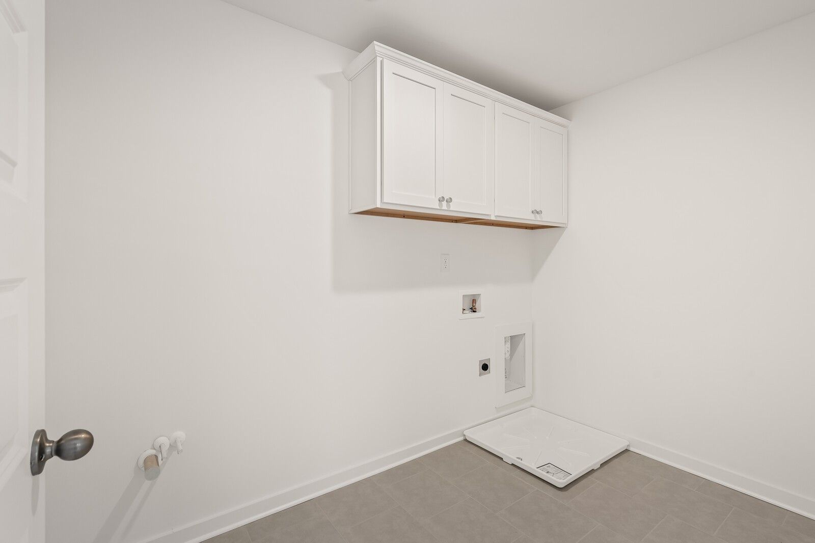 Laundry room with white cabinets and tile floor in The Willow D floor plan at Benders Cove, Mt. Juliet, Tennessee.
