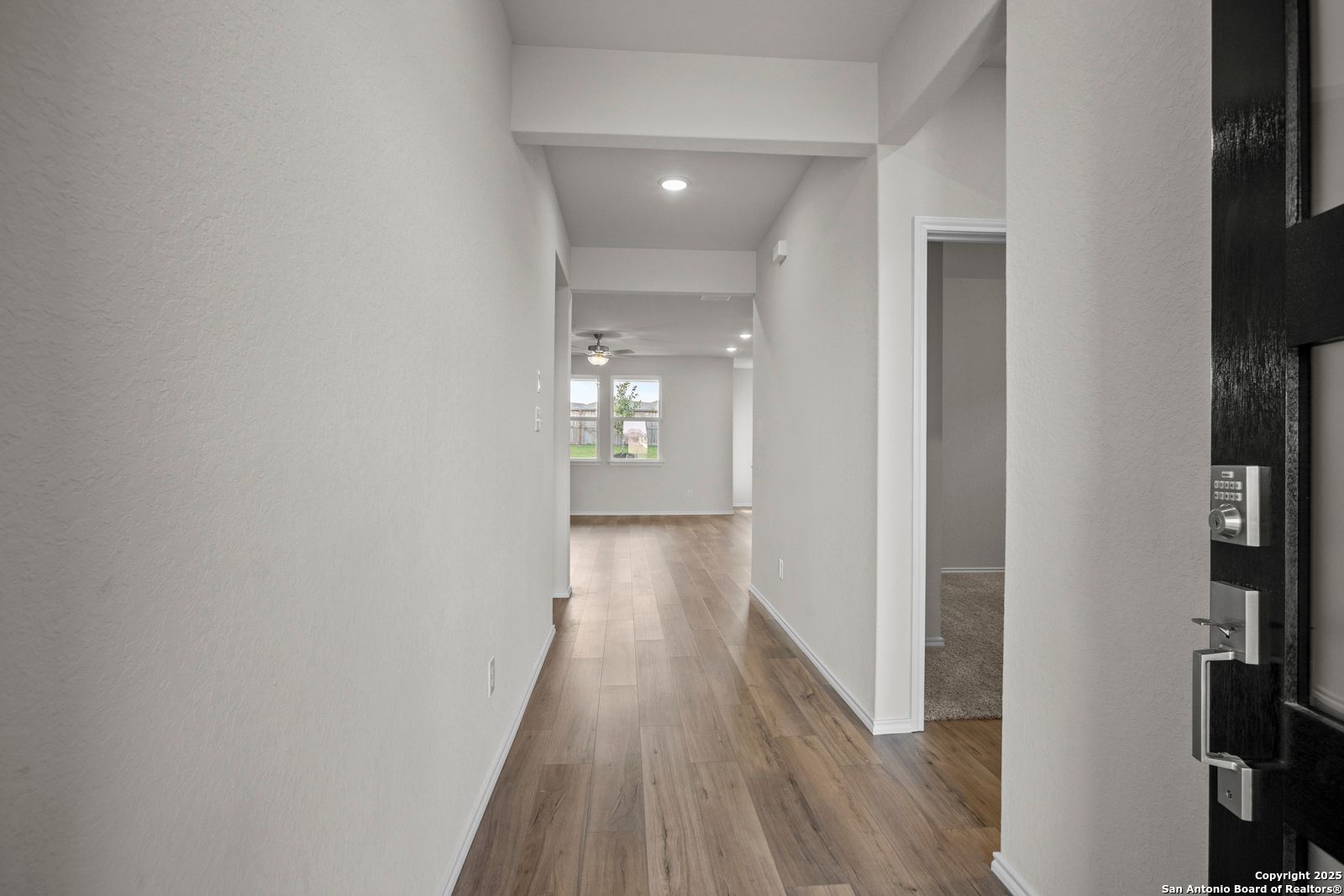 Bright hallway with light wood floors, recessed lights and ceiling fan in The Asheville J 3-bedroom home, San Antonio, Texas
