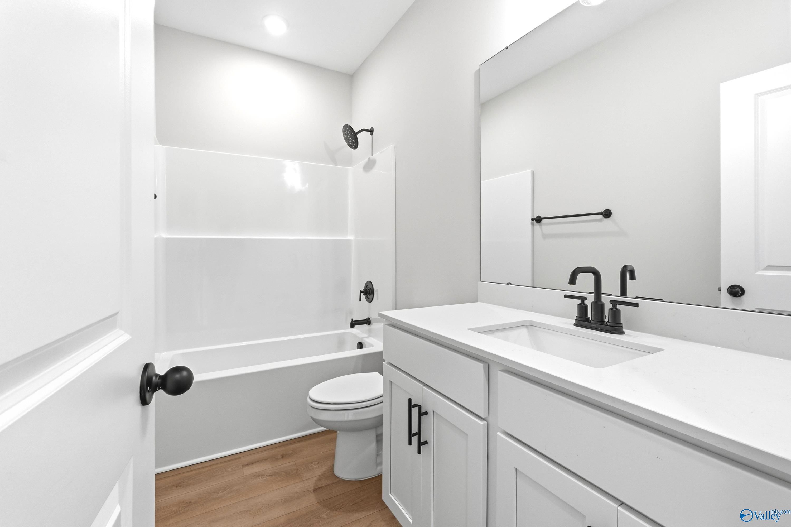 Modern bathroom with white vanity, matte black fixtures, and tub-shower combo in The Daphne C floor plan, Flint Meadows.