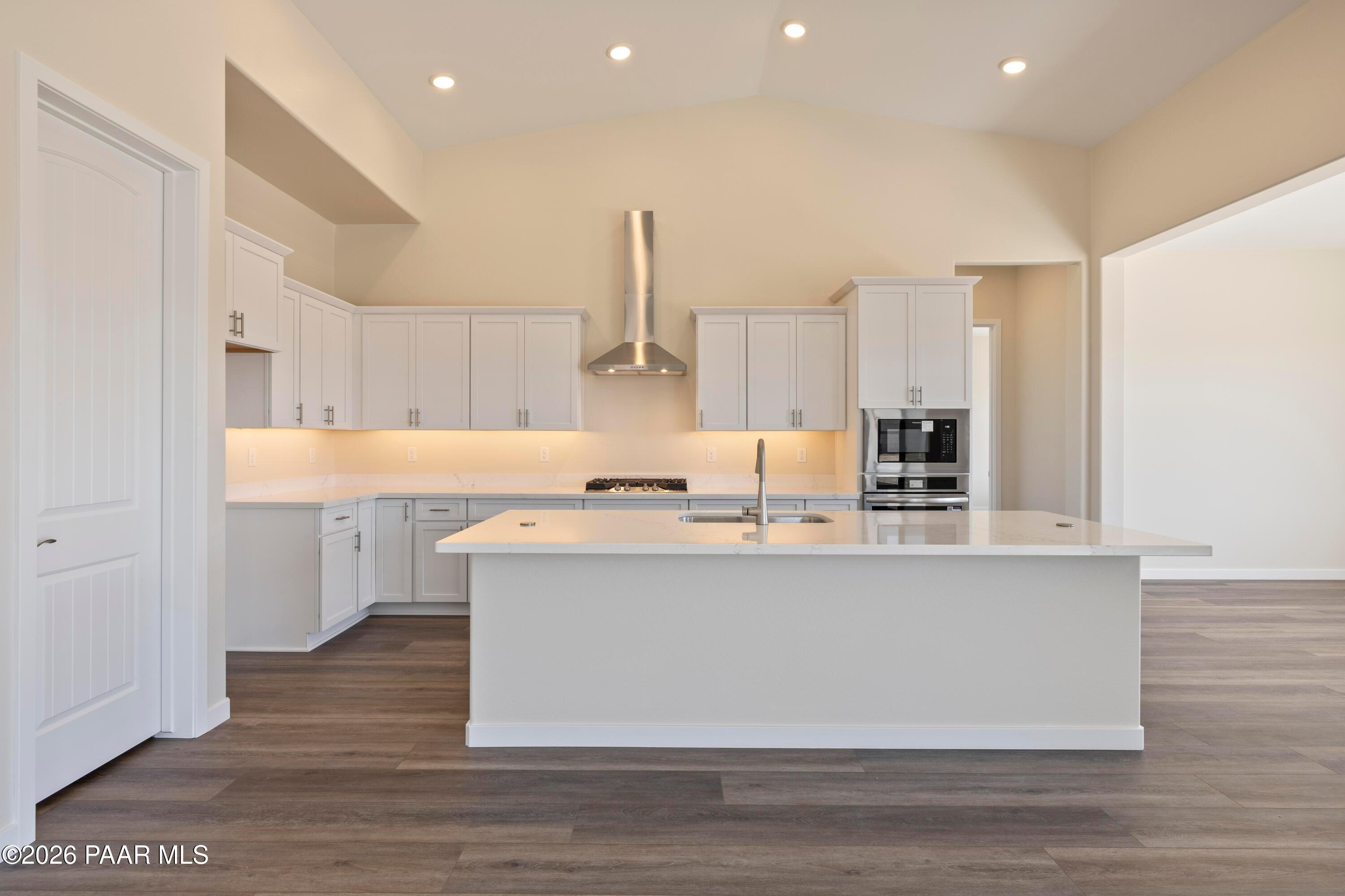Modern white kitchen with large island, stainless appliances, recessed lighting in Davidson Homes Soleil E, Prescott AZ