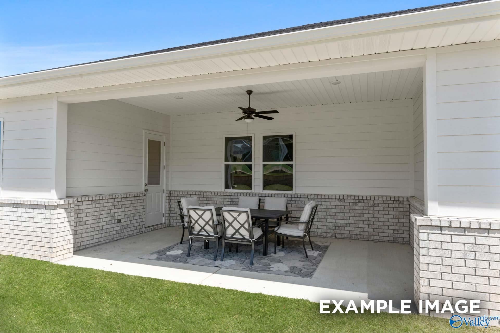 Covered back patio with outdoor dining set at The Haven D floor plan in The Meadows at Hampton Cove, Owens Cross Roads, AL.