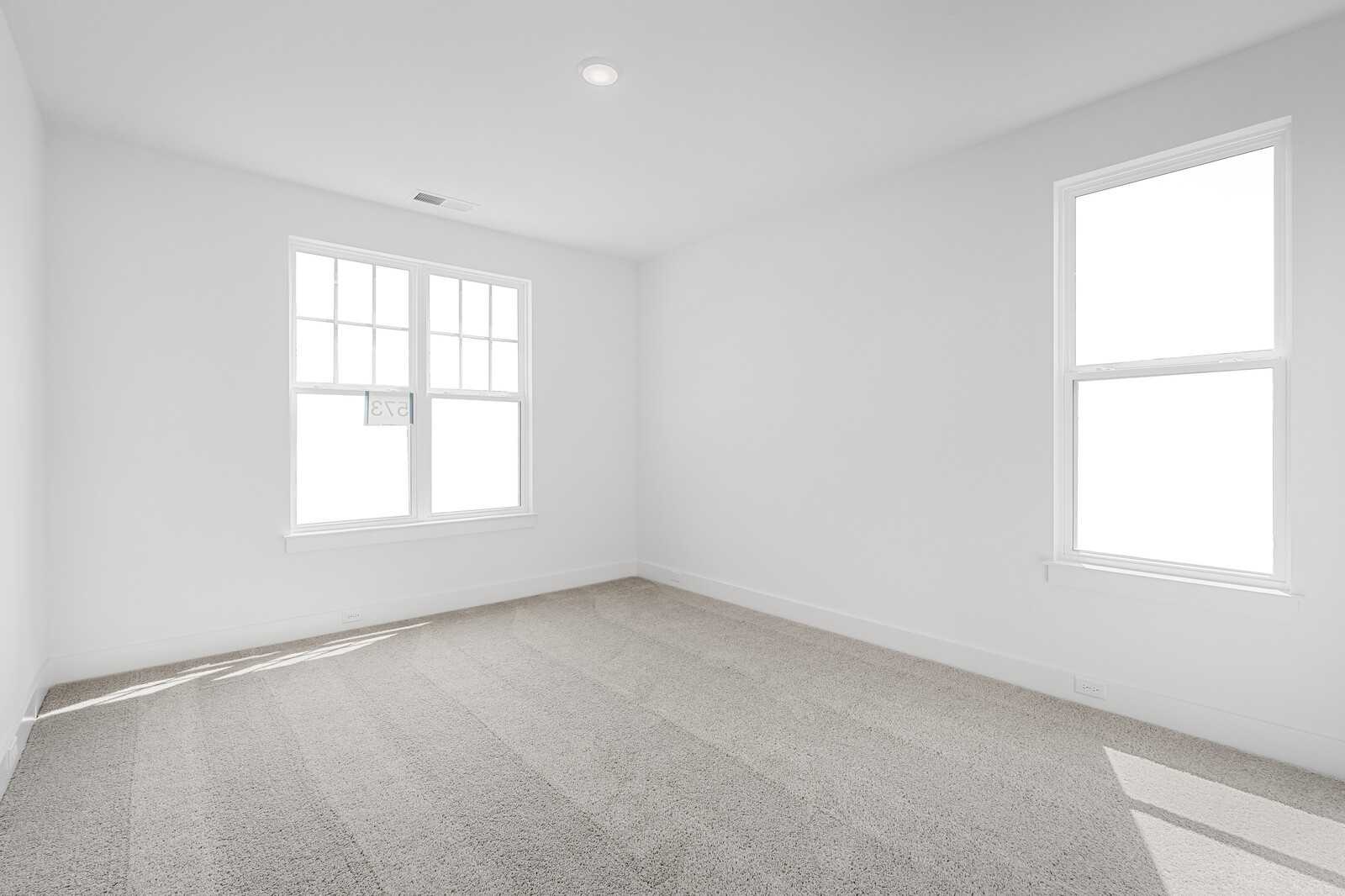 Bright empty bedroom with large windows and neutral carpet in Davidson Homes The Hathaway plan, Shelton Square, Murfreesboro, TN