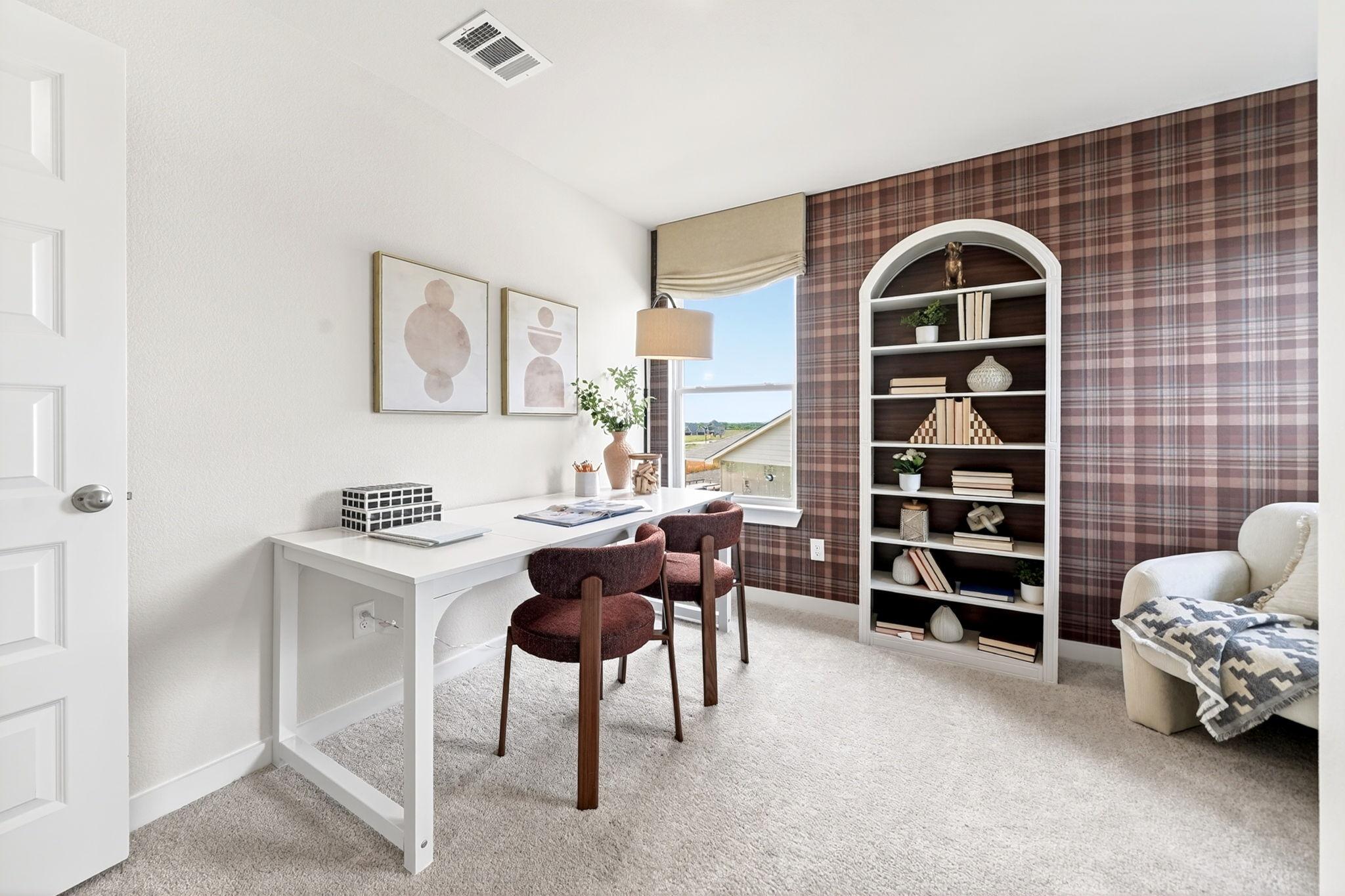 Cozy home office with white desk, maroon chairs, plaid wallpaper, arched bookshelf and window view in Heartland Texas by Davidson Homes