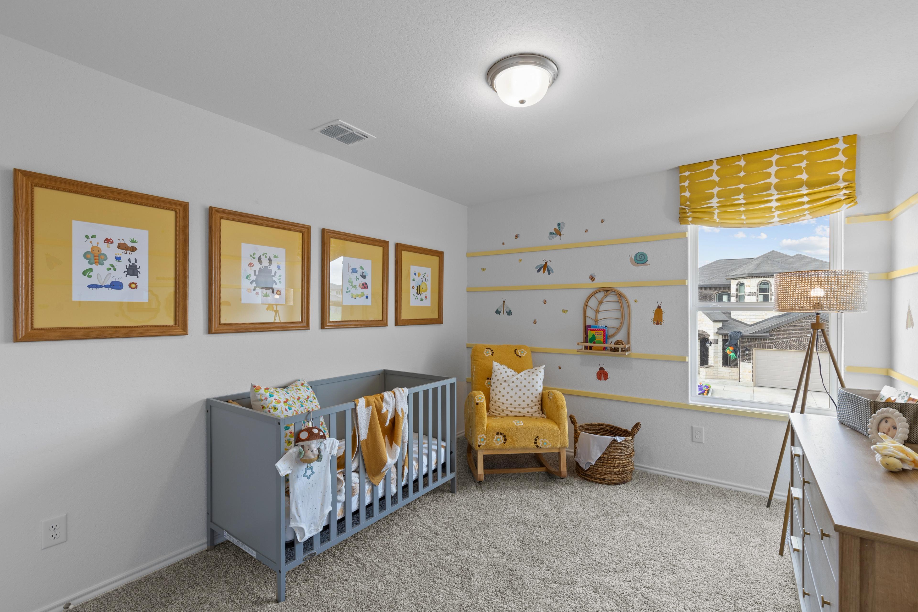 Cozy nursery with gray crib, yellow rocking chair, and framed sea art at Horizon Pointe in Converse, Texas by Davidson Homes