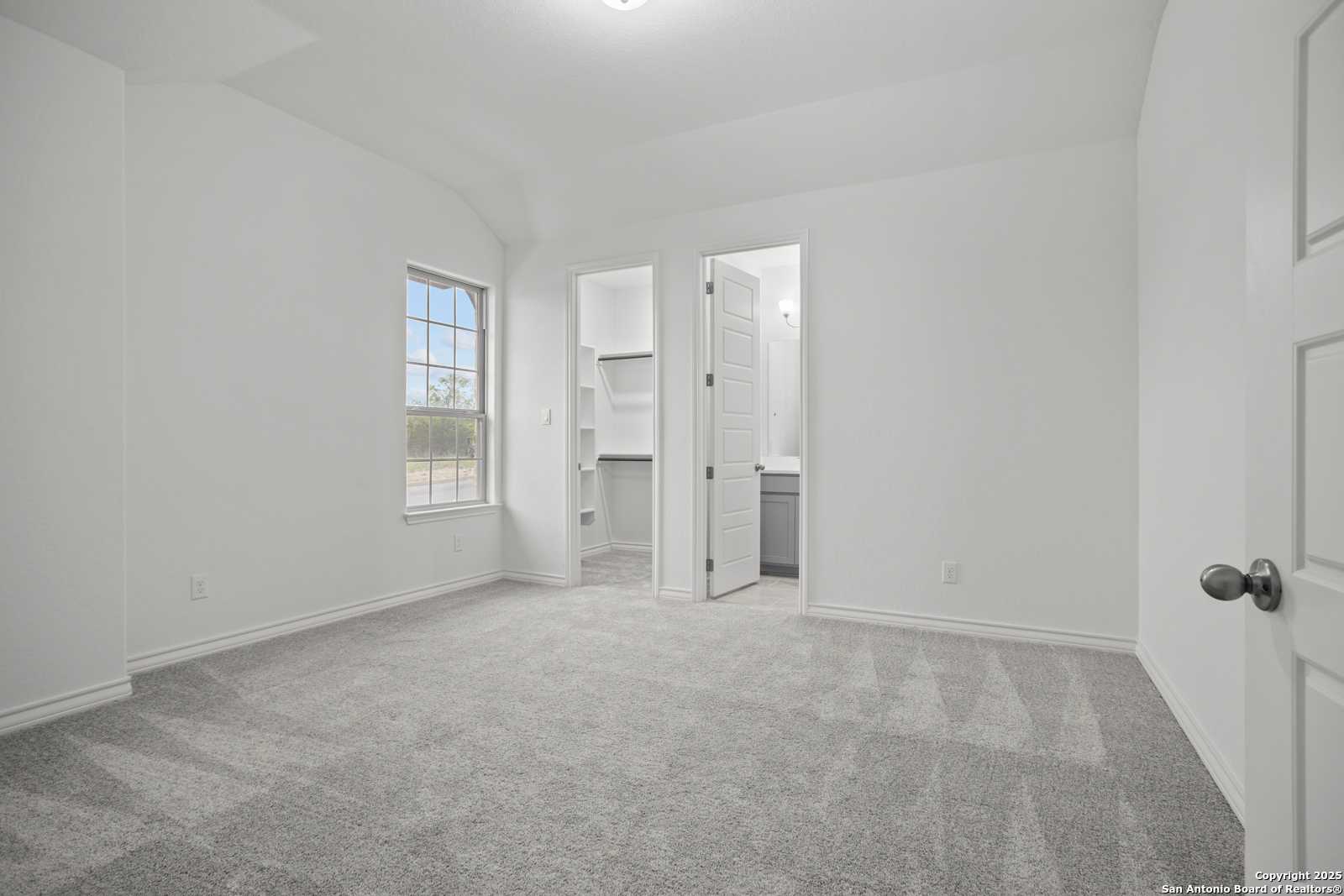 Spacious secondary bedroom featuring walk-in closet and en-suite bath in Davidson Homes The Summerlin B, Castroville, Texas