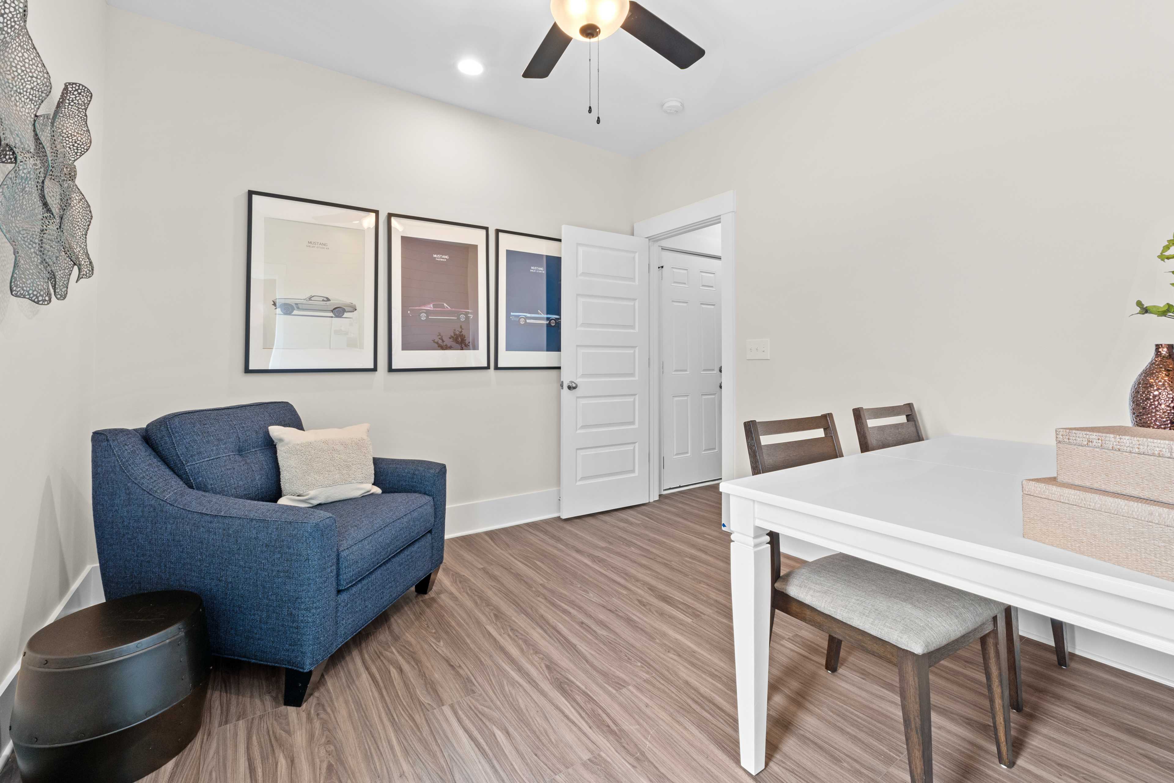 Cozy dining nook in Ivy Hills Toney Alabama by Davidson Homes with blue armchair white table hardwood floors and wall art