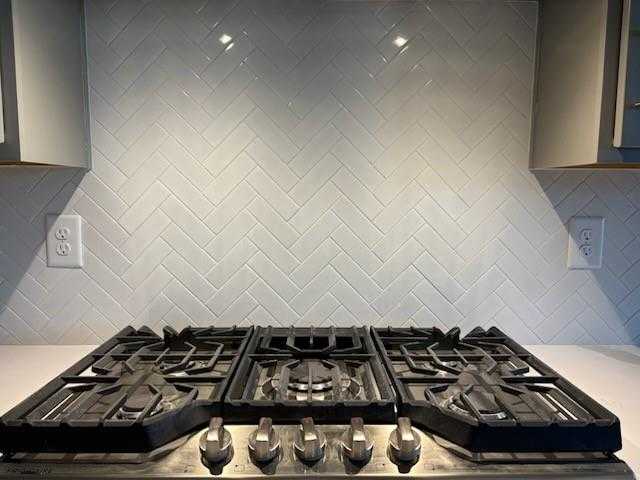 Modern gas range on white quartz countertop with herringbone subway tile backsplash in Marion A kitchen, Davidson Homes, Winder GA