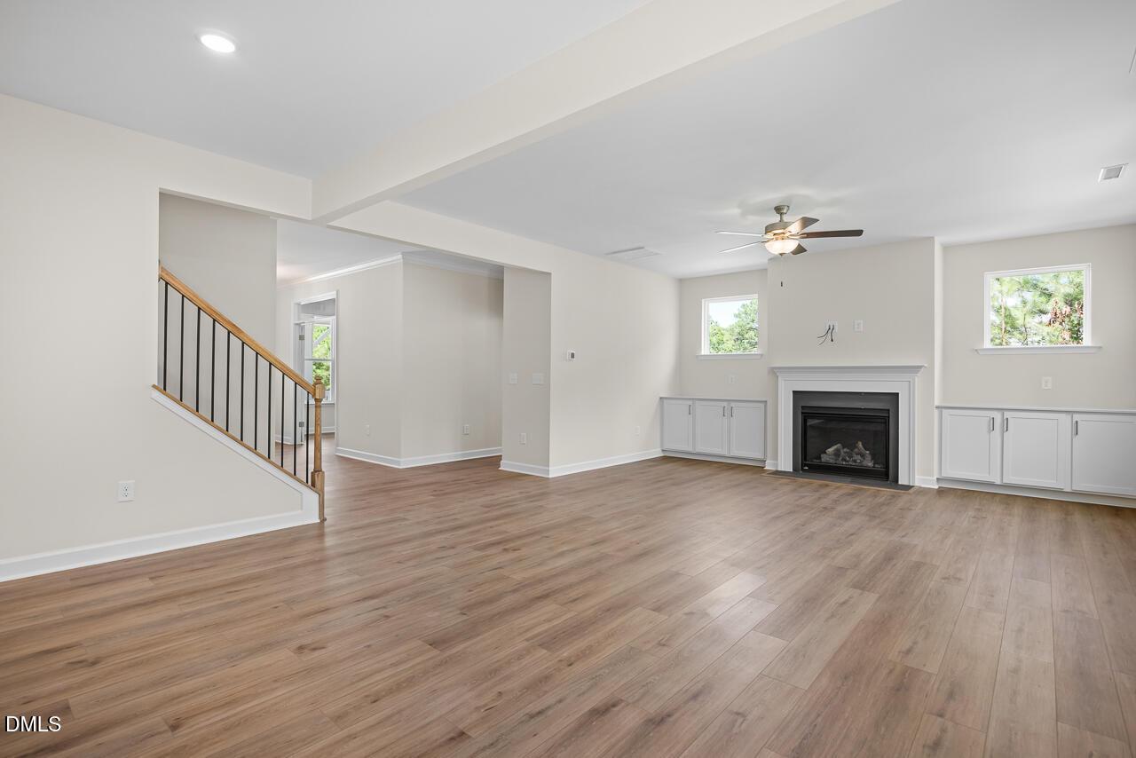 Spacious living room with fireplace and wood-style flooring in The Hickory II B floor plan by Davidson Homes in Aberdeen, NC.
