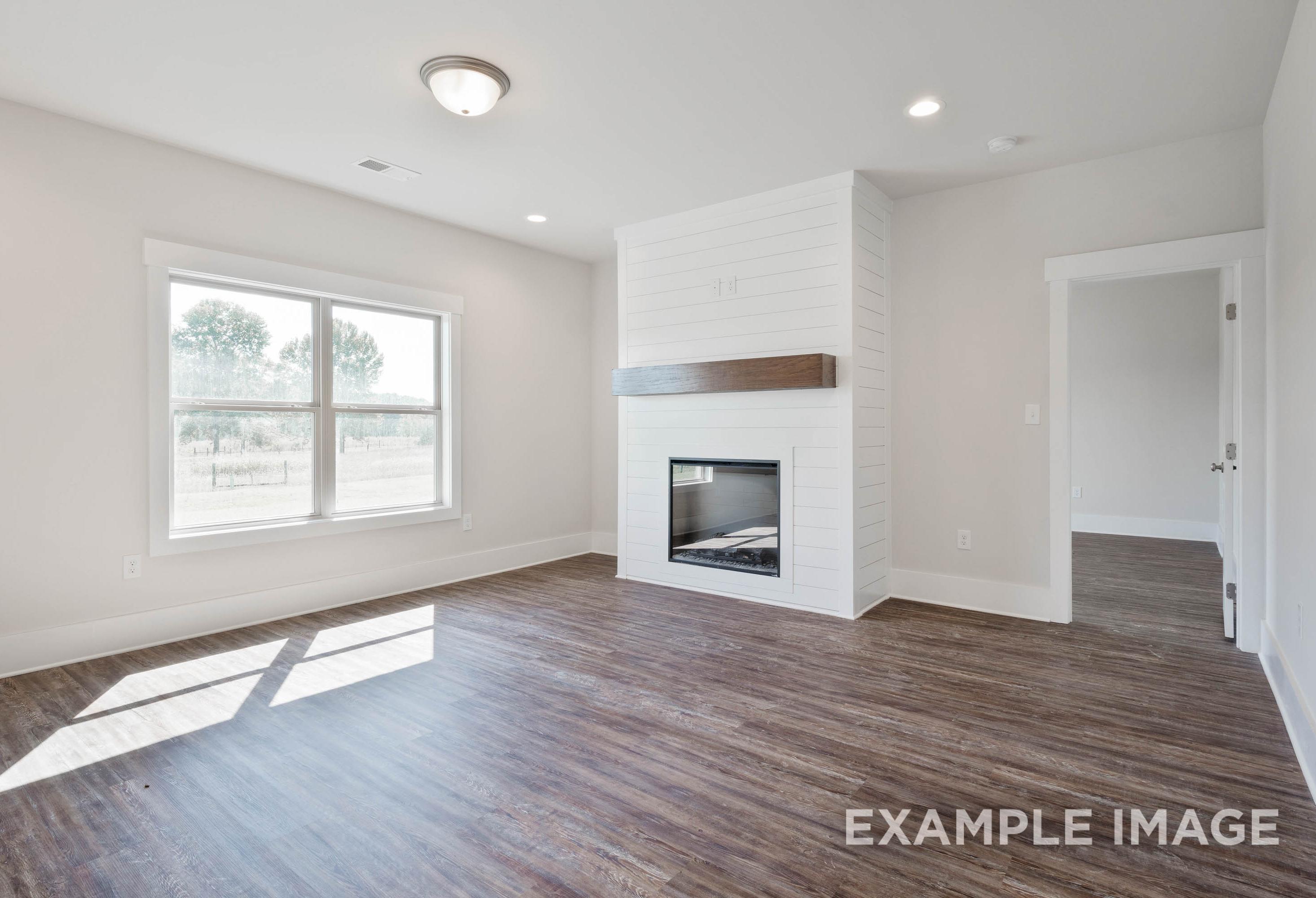 Living room in The Richmond D featuring a shiplap fireplace with wood mantel and open-concept floor plan design.