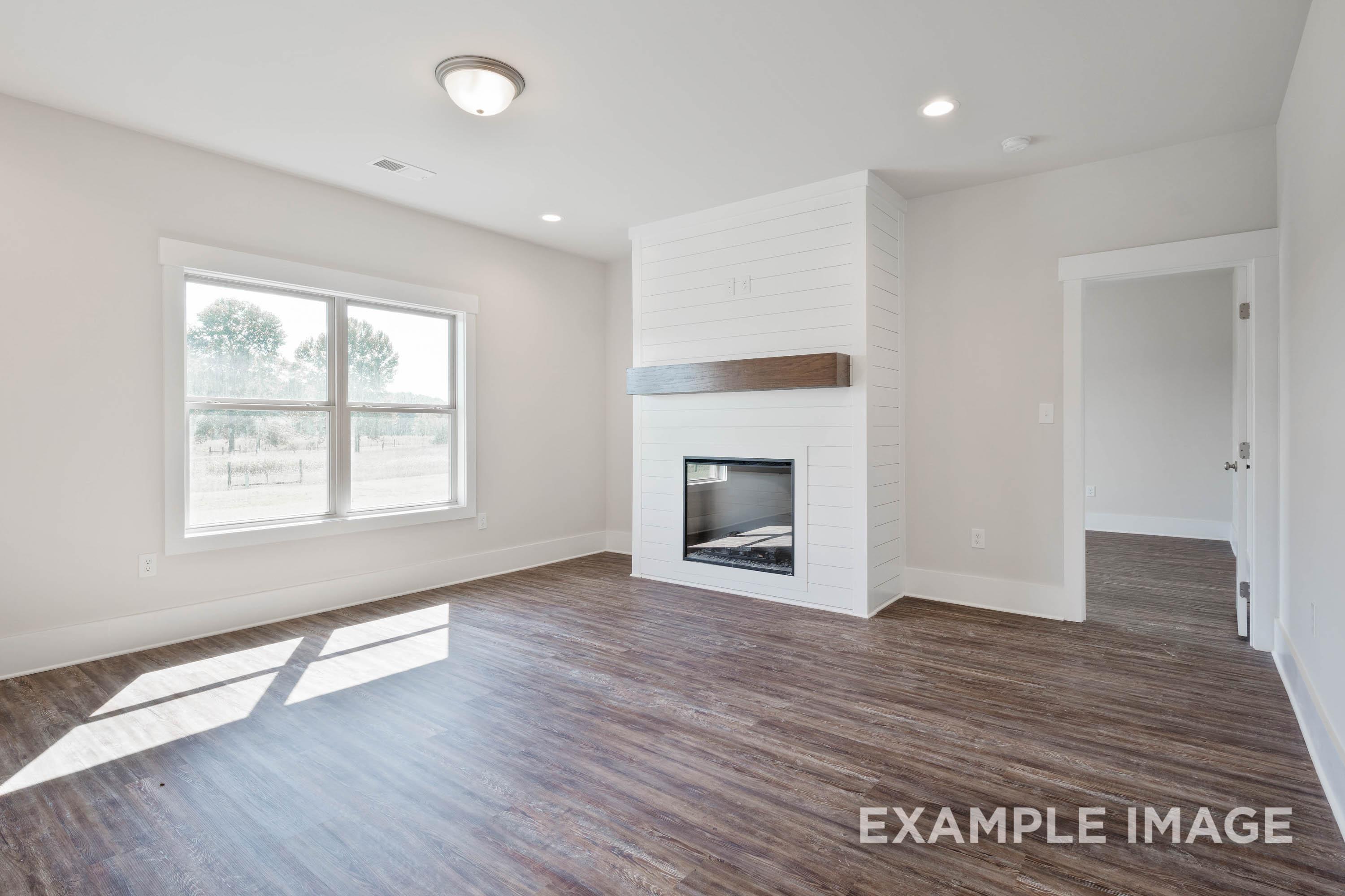 Living room in The Richmond D featuring a shiplap fireplace with wood mantel and open-concept floor plan design.
