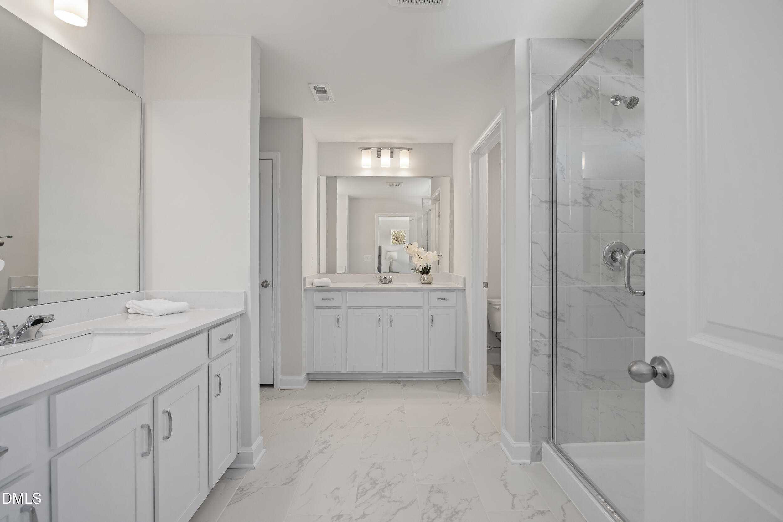 Modern master bathroom with double vanity, frameless glass shower, and white subway tile floor in Davidson Homes The Preston C, Lillington, NC