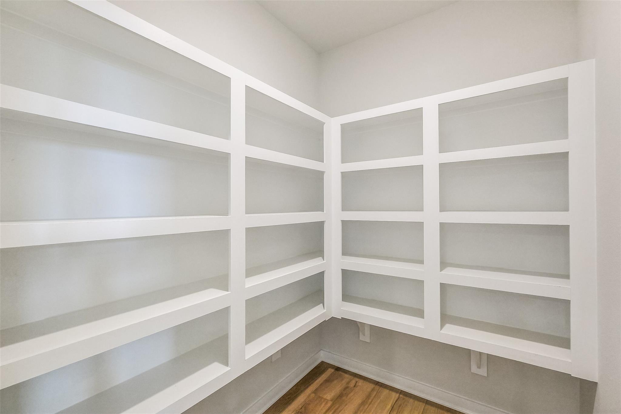 Spacious white corner pantry with built-in shelves in Davidson Homes The Tierra B, Emberly, Beasley, Texas