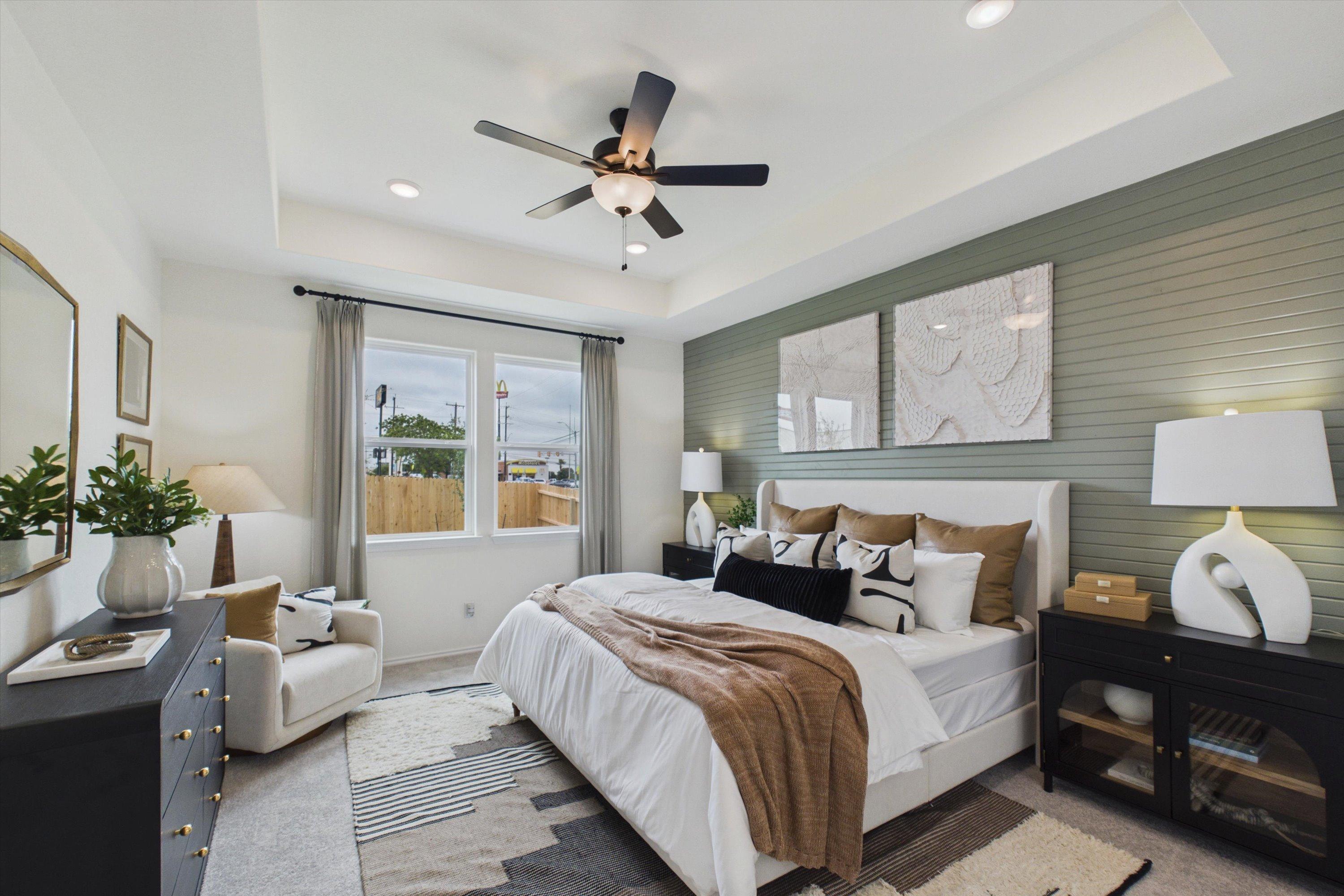 Spacious primary bedroom in Rayburn Valley San Antonio TX by Davidson Homes featuring neutral tones, king bed, ceiling fan, and accent wall