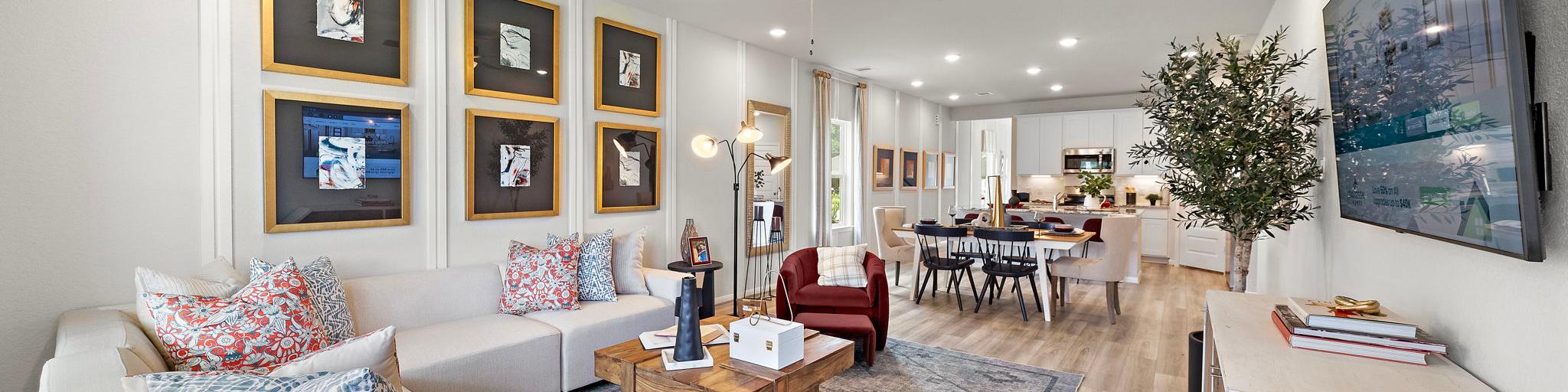 Spacious open-concept living and dining room at Liberty Estates in Cleveland Texas with white sectional sofa, wooden coffee table, and ceiling fan
