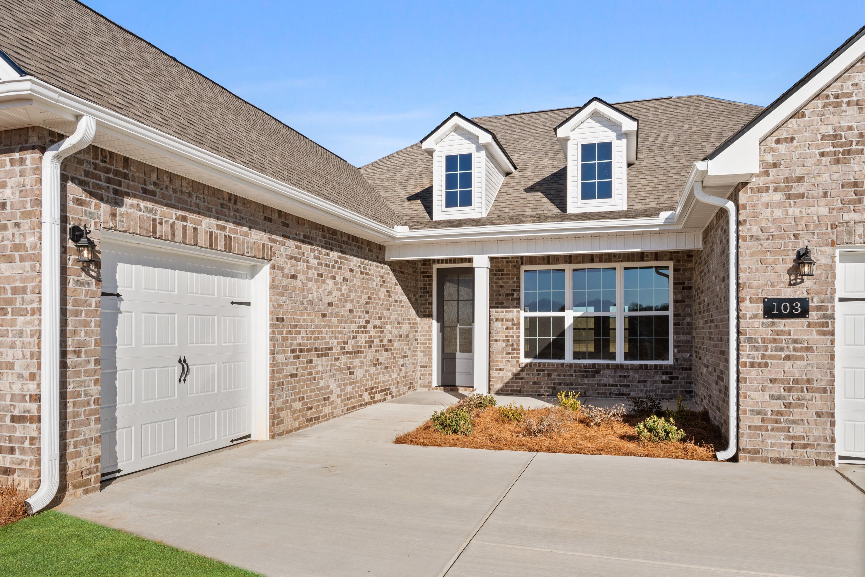 The Valencia 1-story home exterior: brick facade, dormer windows, 3-car garage, Meridianville AL landscaping