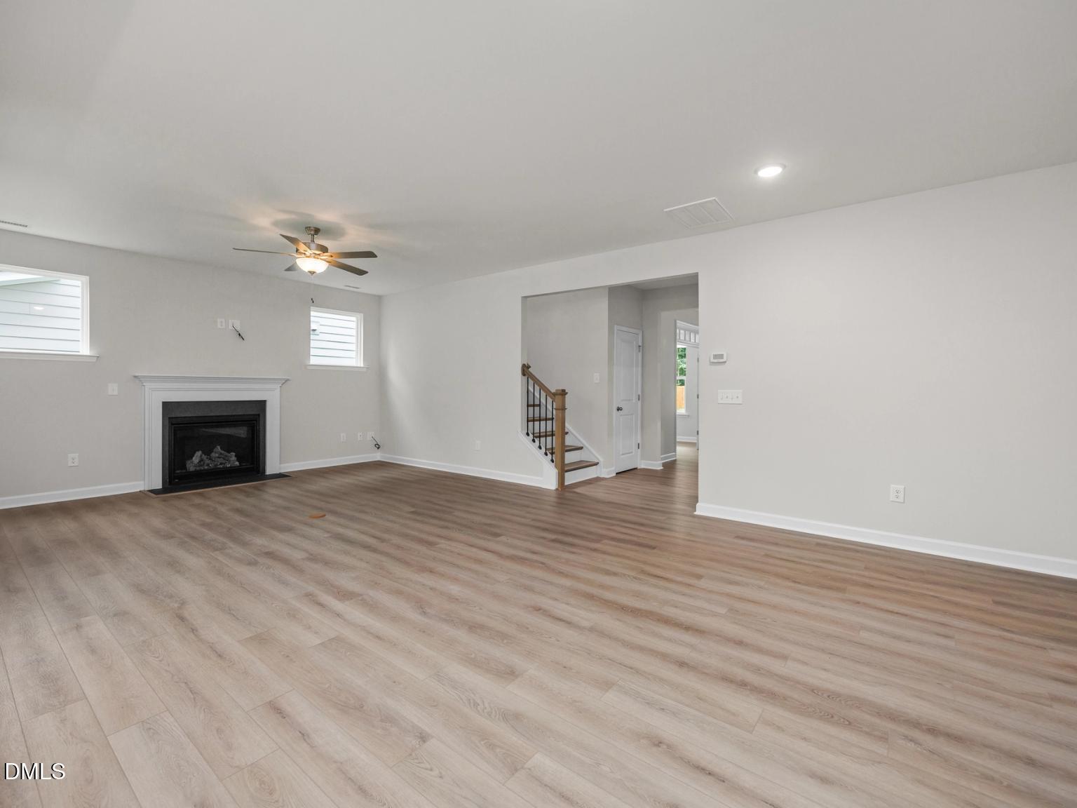 Spacious family room with gas fireplace, light oak hardwood floors, ceiling fan in Davidson Homes The Aspen, Wake Forest, NC