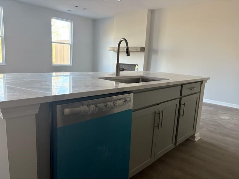 Modern kitchen island with white quartz counters, gray cabinets, stainless sink in Davidson Homes Marion A, Winder, GA