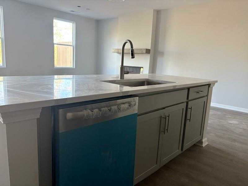 Modern kitchen island with white quartz counters, gray cabinets, stainless sink in Davidson Homes Marion A, Winder, GA