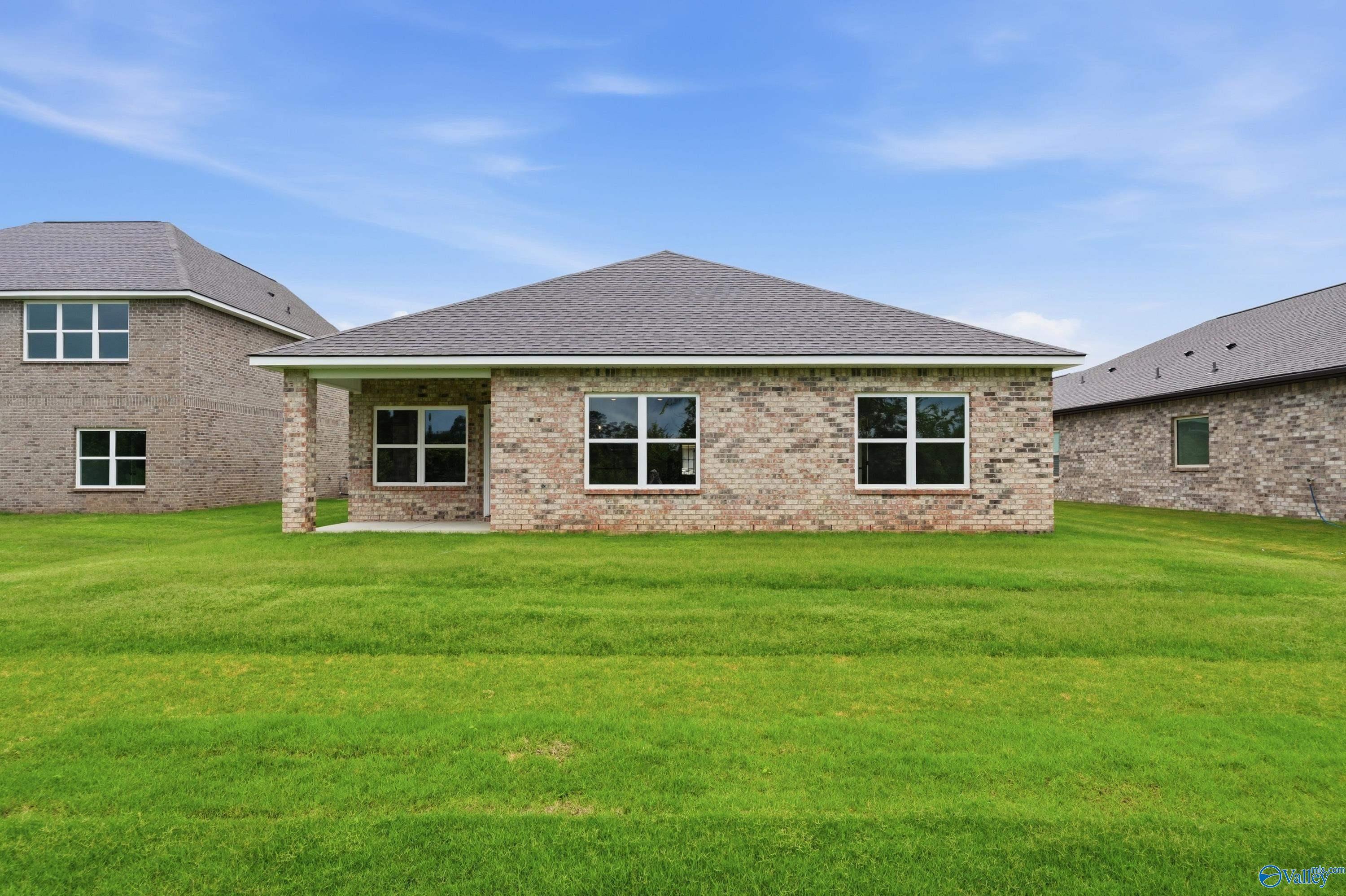 Rear exterior view of The Daphne C floor plan by Davidson Homes in Ivy Hills, Toney, Alabama with large grassy yard.