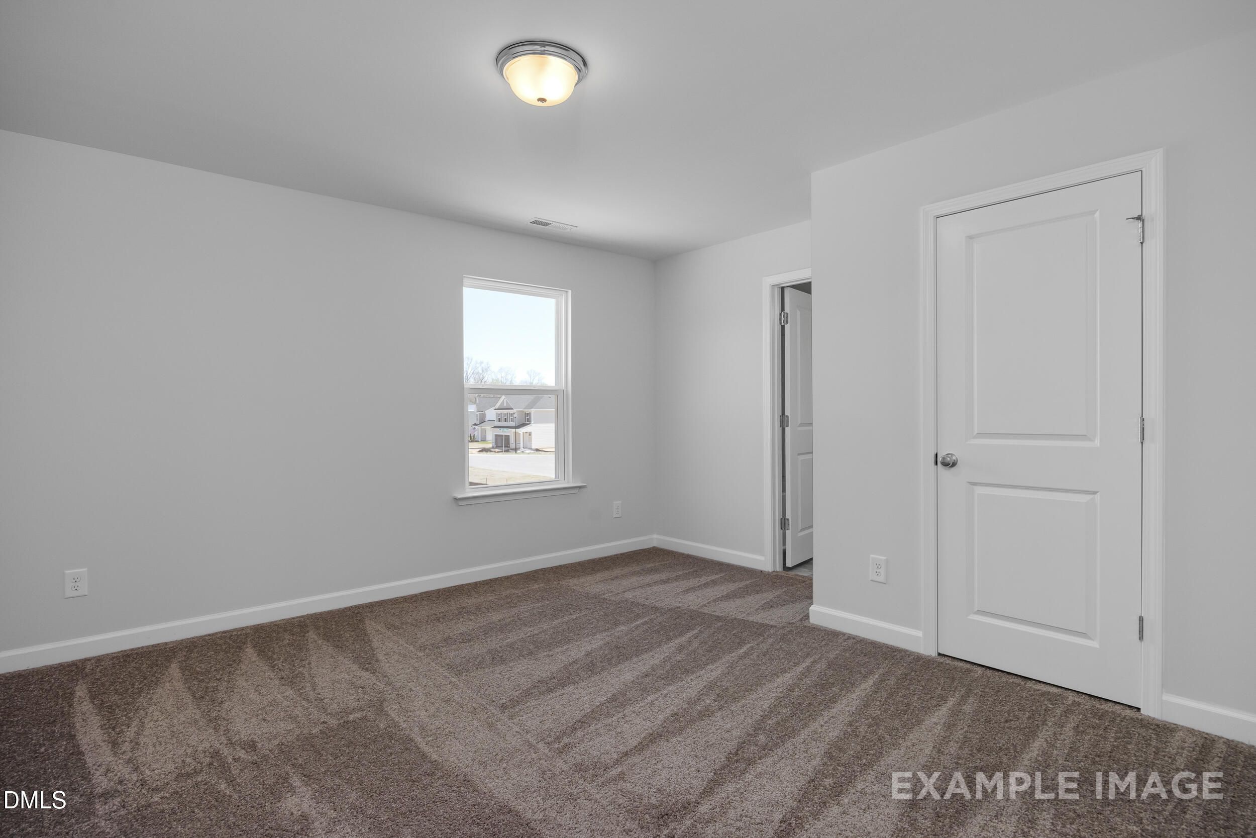 Bright, carpeted bedroom with neutral walls in The Gavin A floor plan by Davidson Homes in Gregory Village, Lillington, NC.