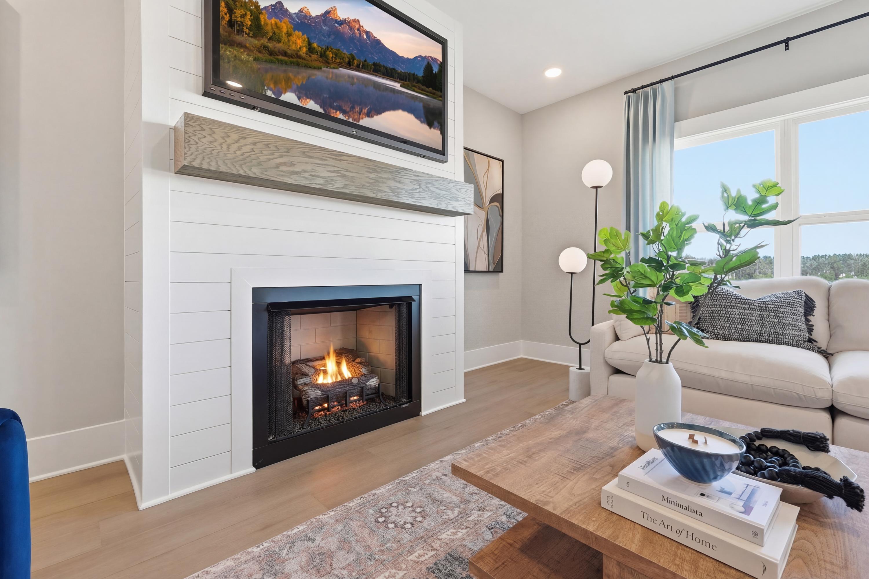 Cozy living room in Berry Cove New Market Alabama by Davidson Homes featuring shiplap fireplace, gas logs, and mounted TV